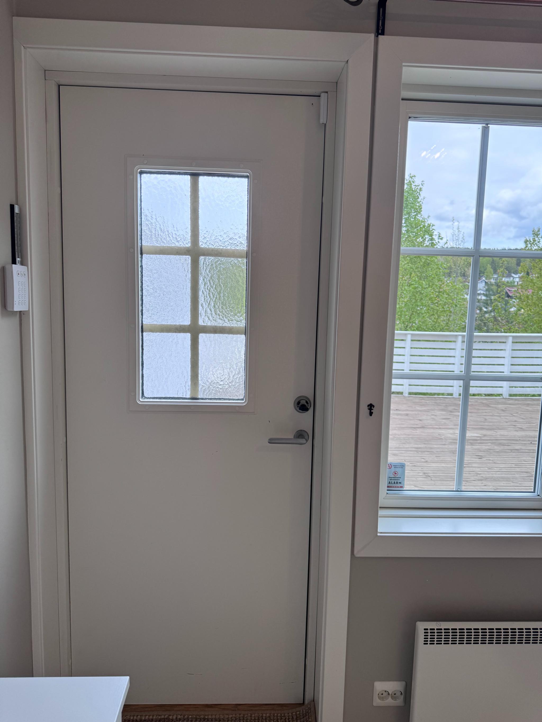 Ytterdøren lukket med utsikt mot terrassen og fra terrassen ut mot Prinsdal.