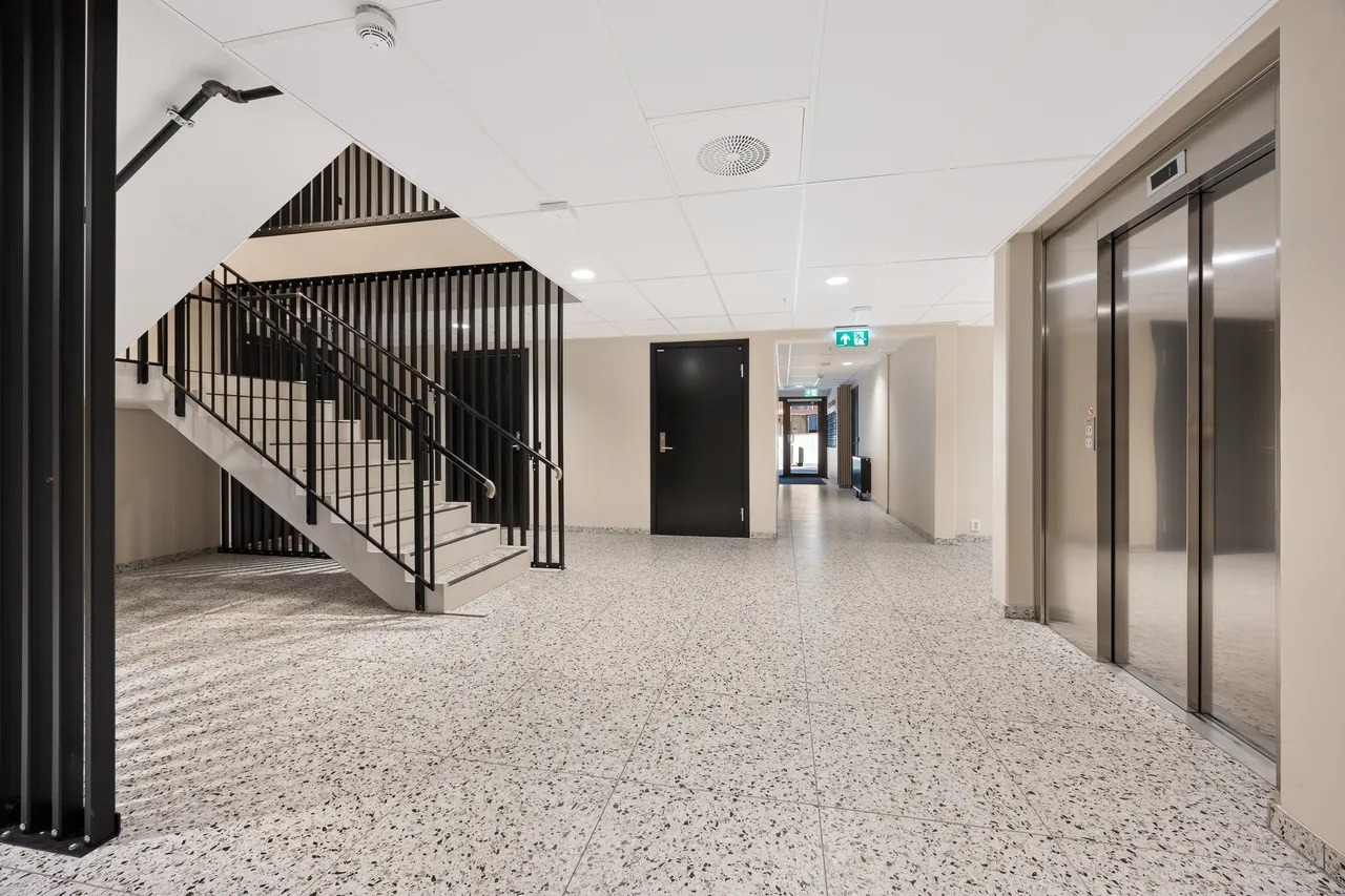 Inngangshall med heis og trapp:
Romslig og stilren felles inngangshall med både heis og trapp – lett tilgjengelig for alle, med praktisk tilkomst til hver etasje.