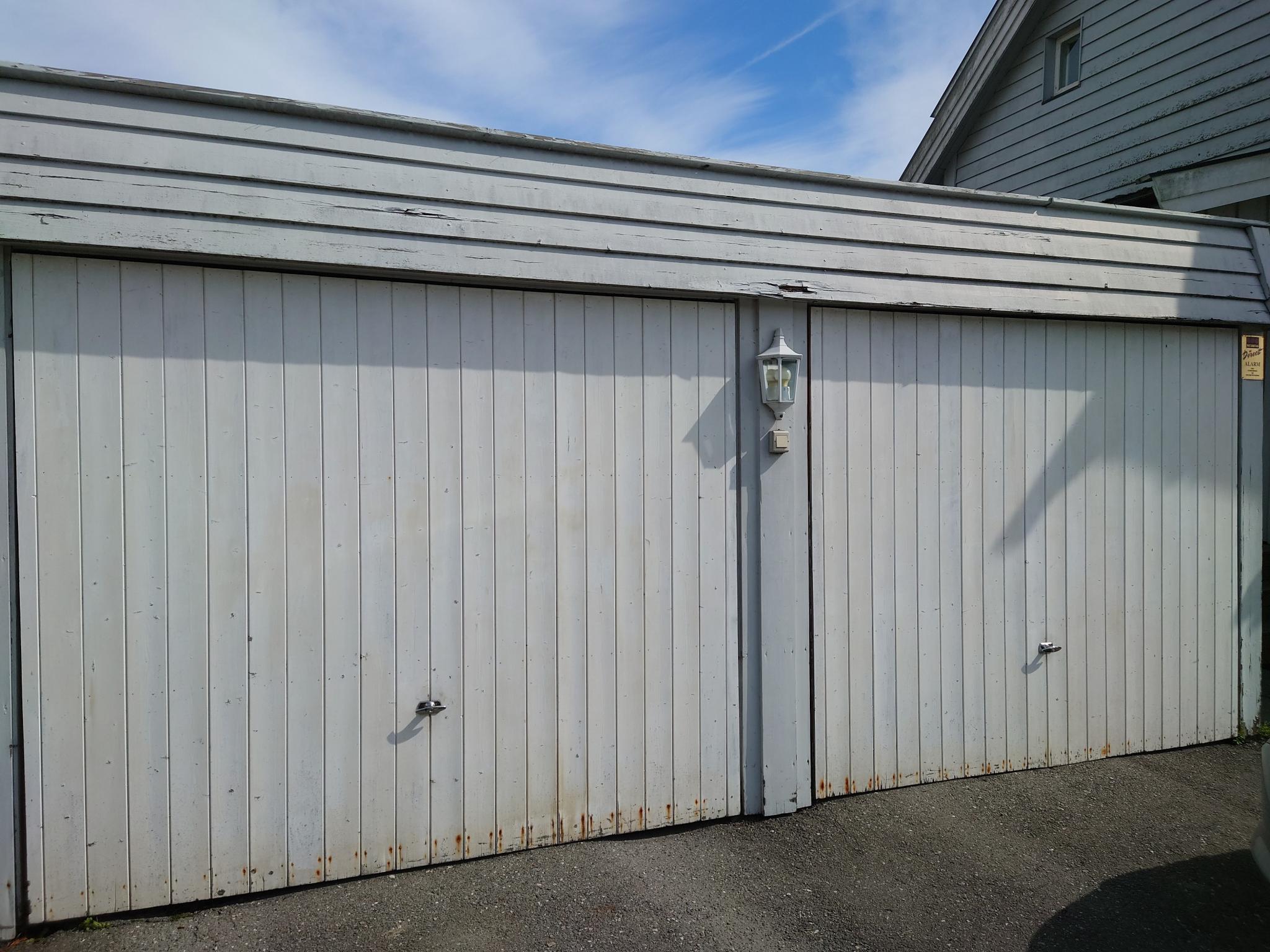 Leiligheten disponerer garasjen til høyre i bildet, og parkeringsplass utenfor. 