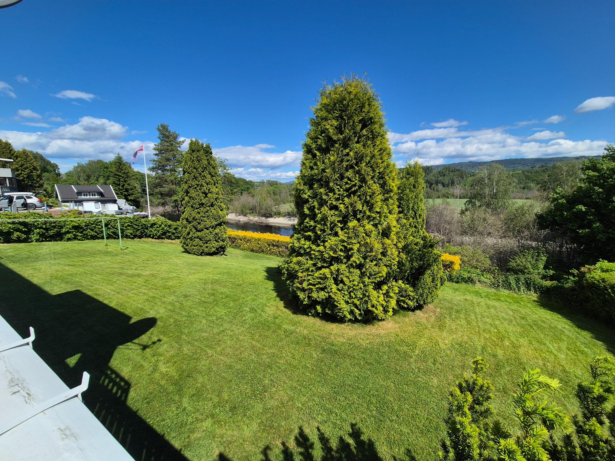Fin utsikt over hagen og elva fra balkongen.