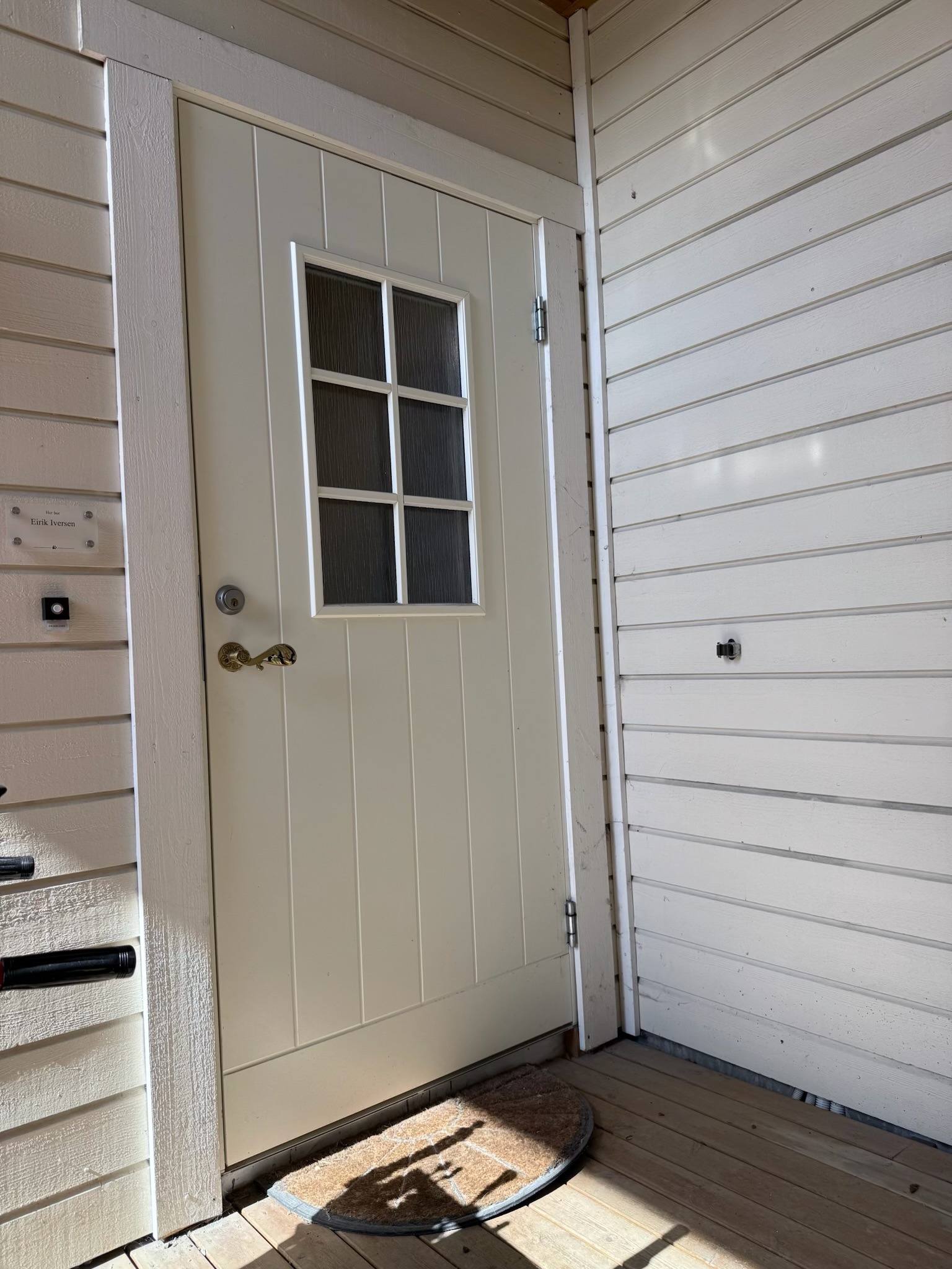 Hovedinngang, ligger godt skjermet for vær og vind under tak.