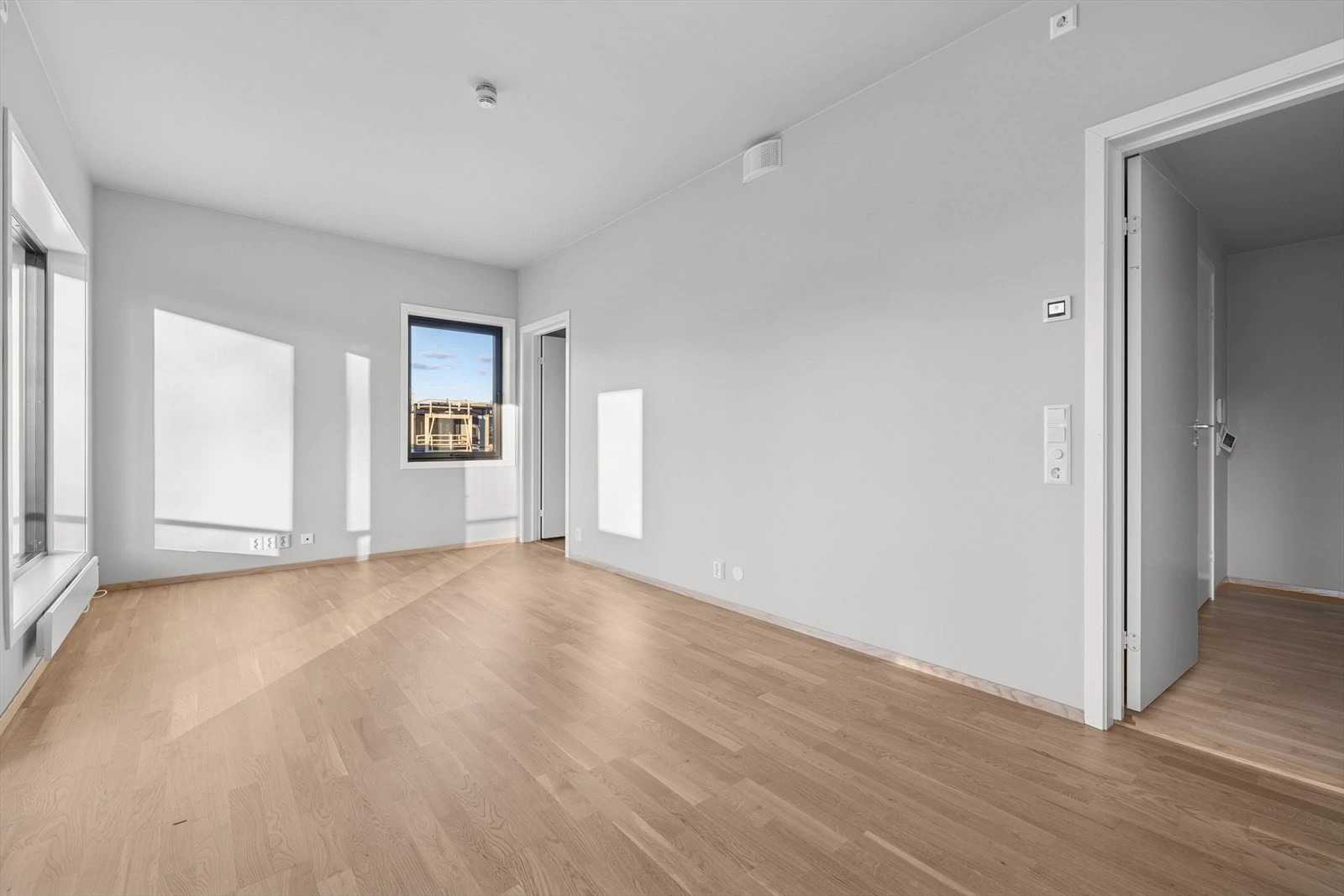 Stor og lys stue med åpen løsning mot kjøkken – her er det lett å trives!

