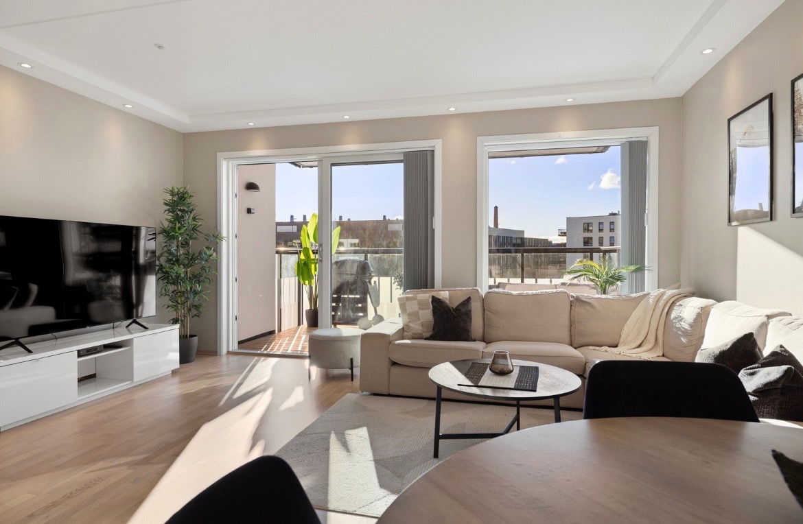 Boligens praktiske planløsning, vinduer i tre retninger og moderne, lyse overflaterflater skaper en innbydende atmosfære.