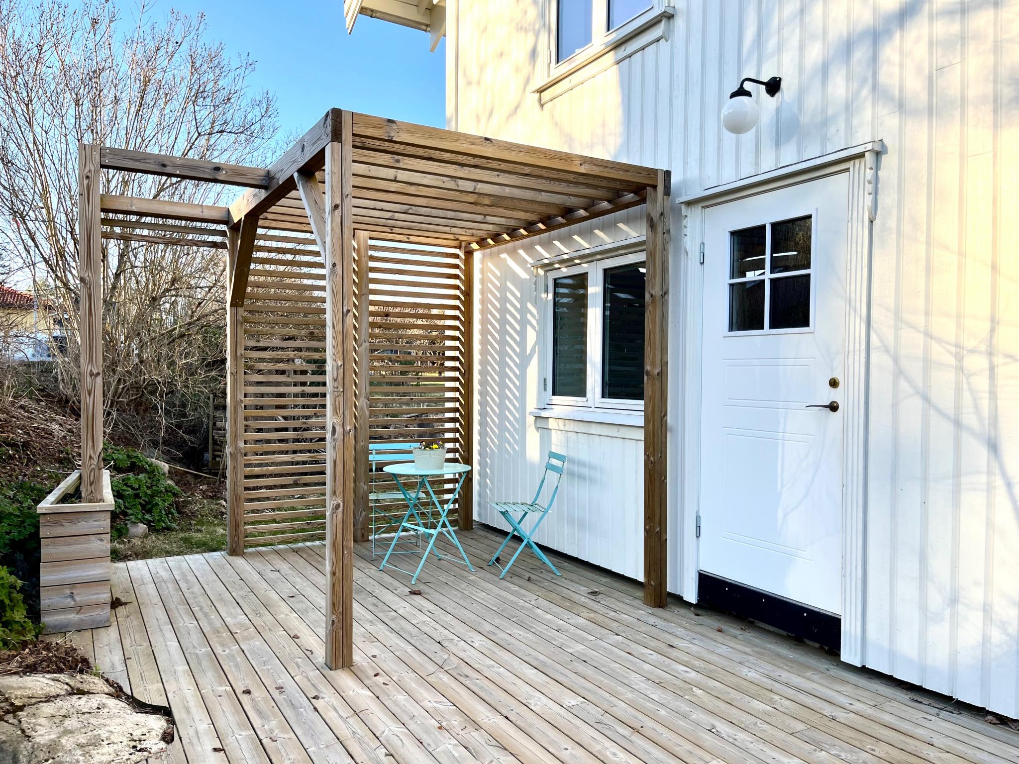 Egen inngang med fin platting og pergola med møbler som følger med.