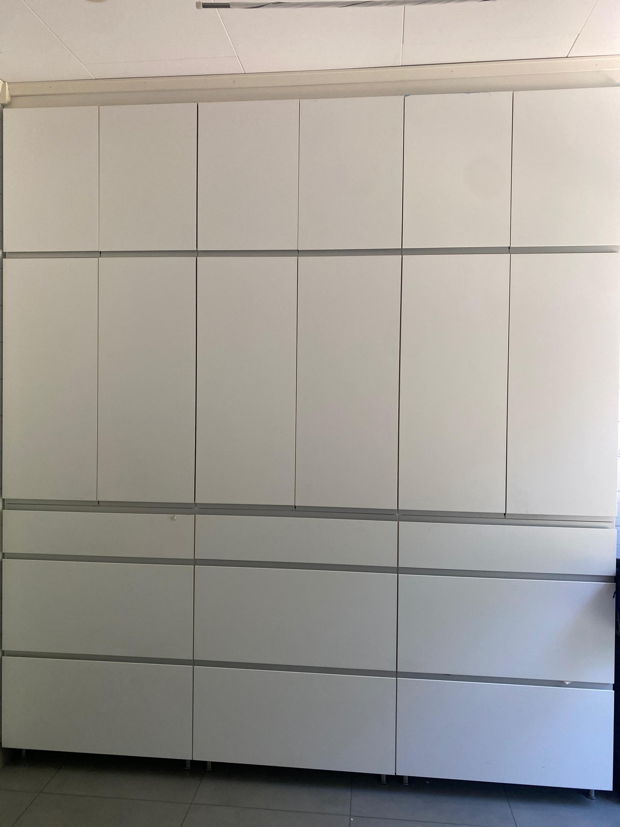 Langvegg med klesskap fra gulv til tak på vaskerommet.