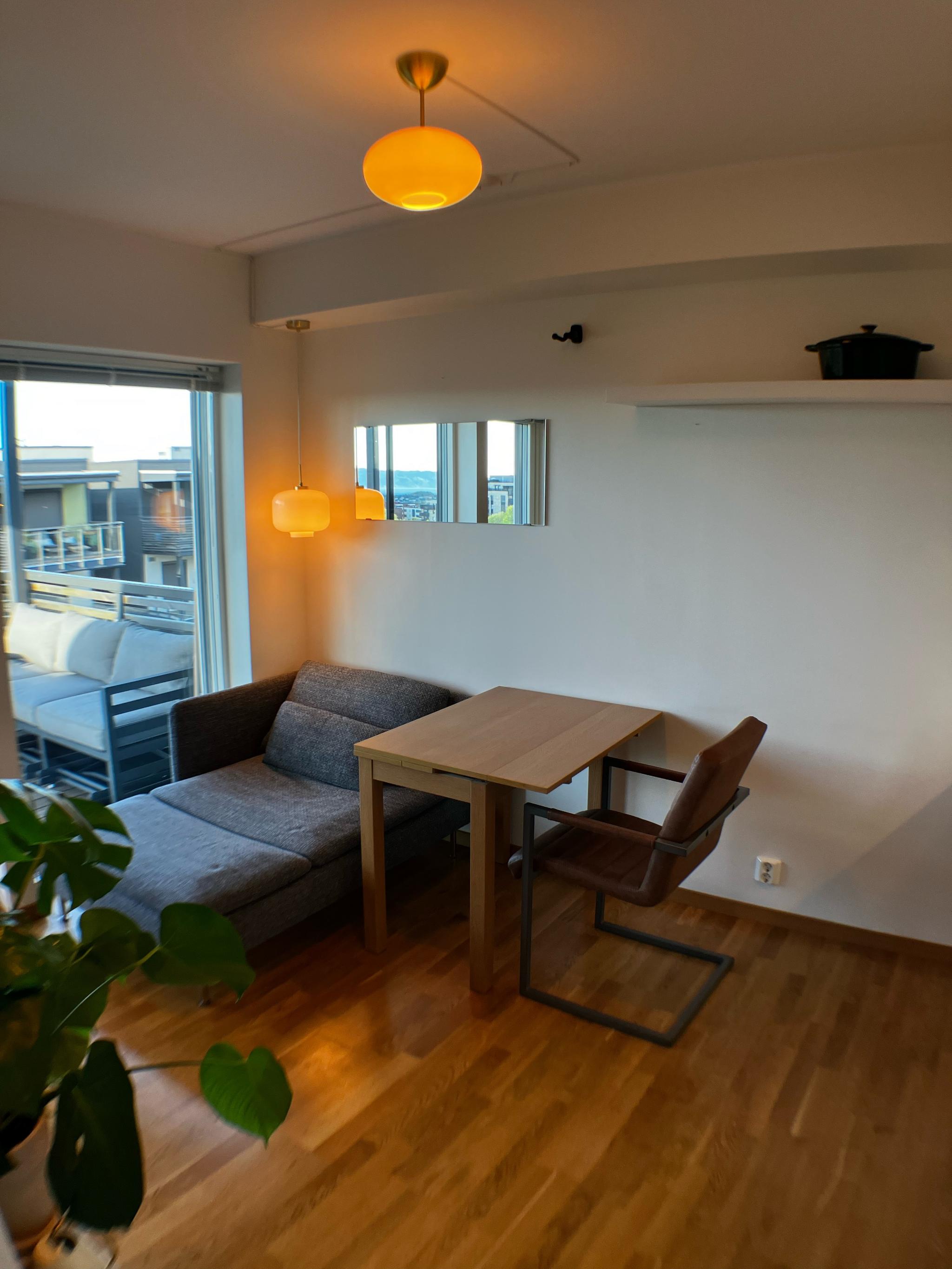 Kjøkken/stue-løsning med spisebord, et par stoler og sofa ny i 2024