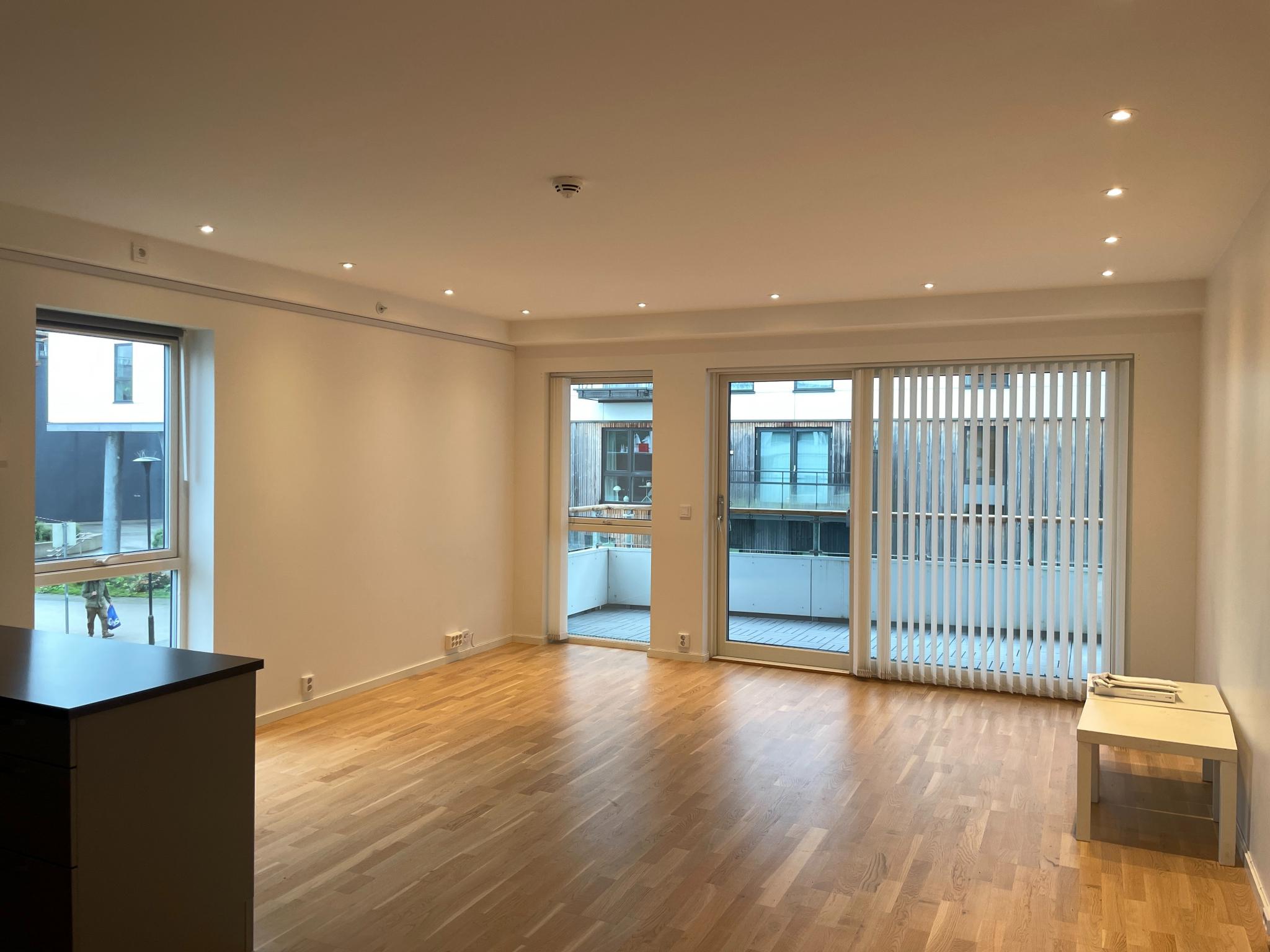 Lys stor stue med plass til sittegrupper. 