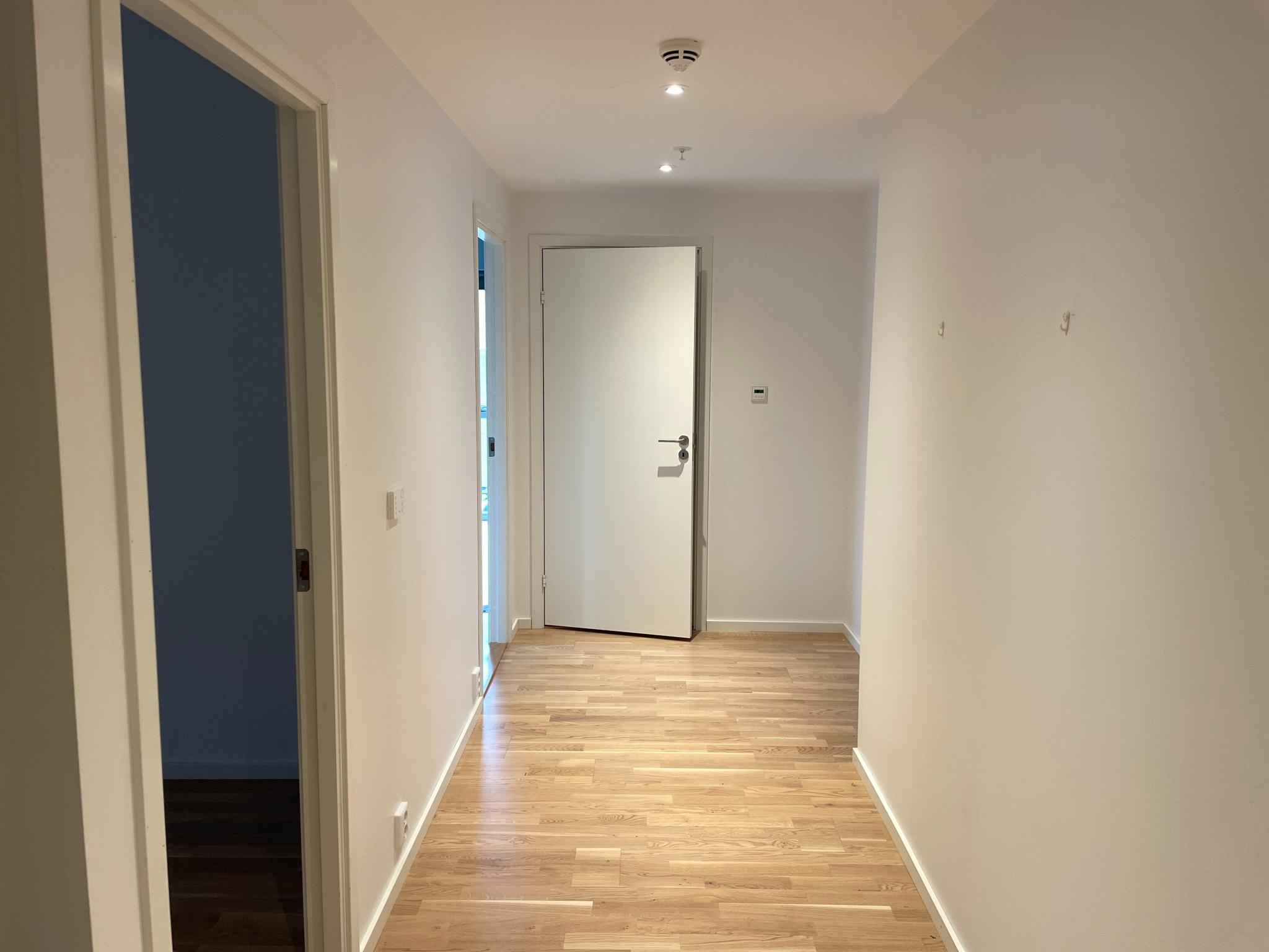 Romslig gang. Her ser man dør til soverom 1, soverom 2 (hovedsoverom) og badet/toalett. 