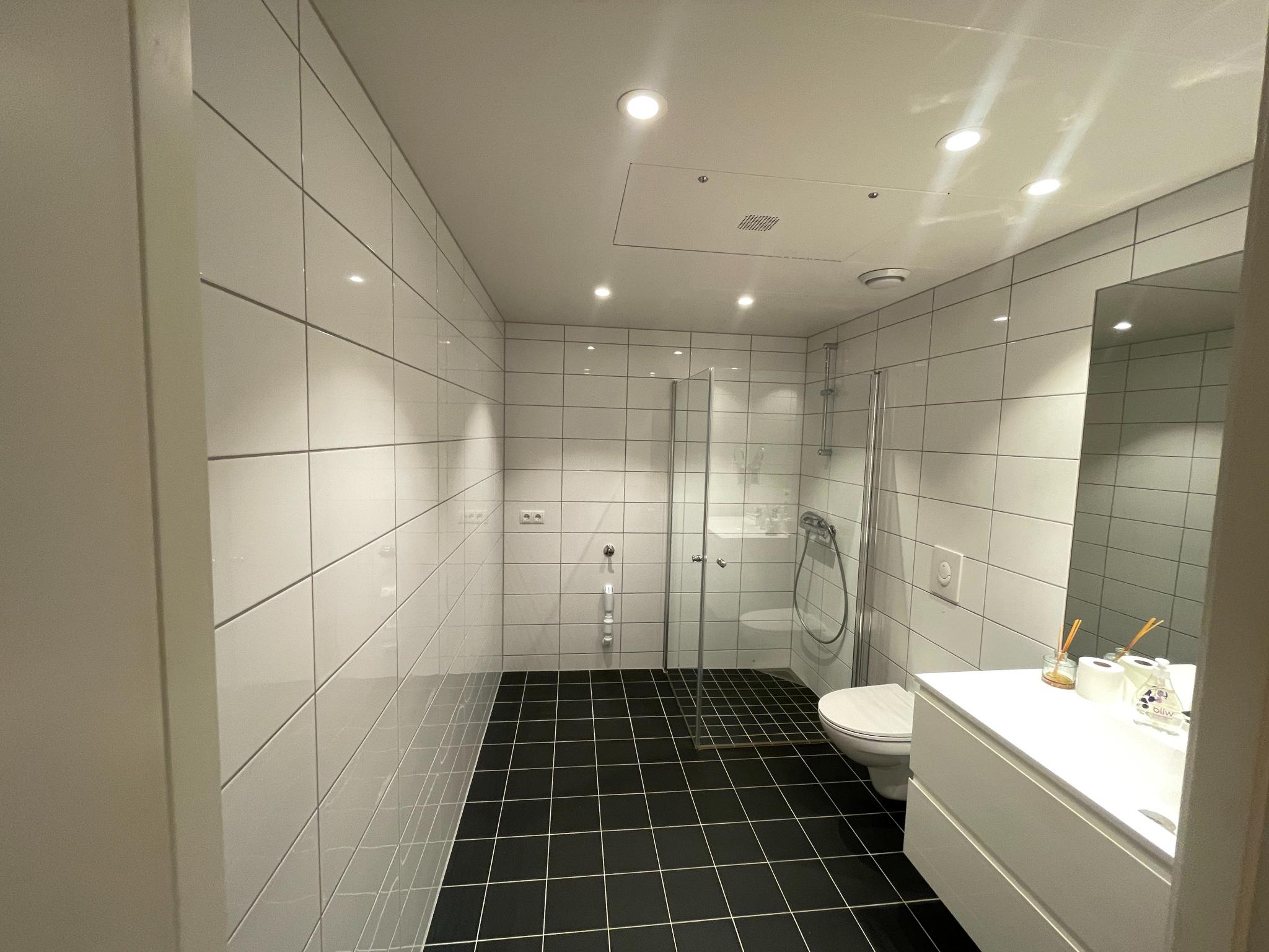 Pent flislagt bad. Servantskap og vegghengt toalett. 