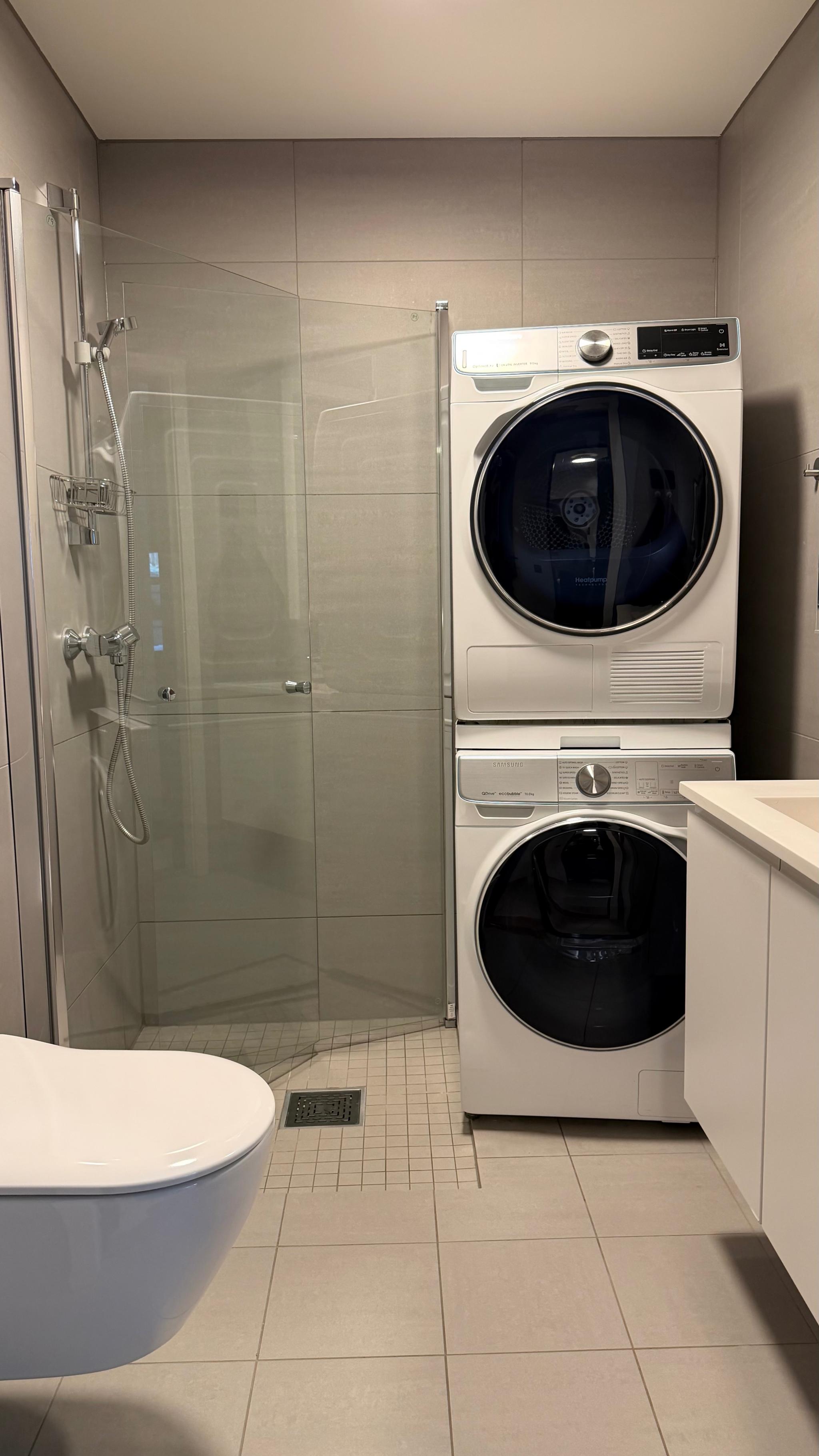 Flislagt bad med moderne innredning, vegghengt toalett og dusj