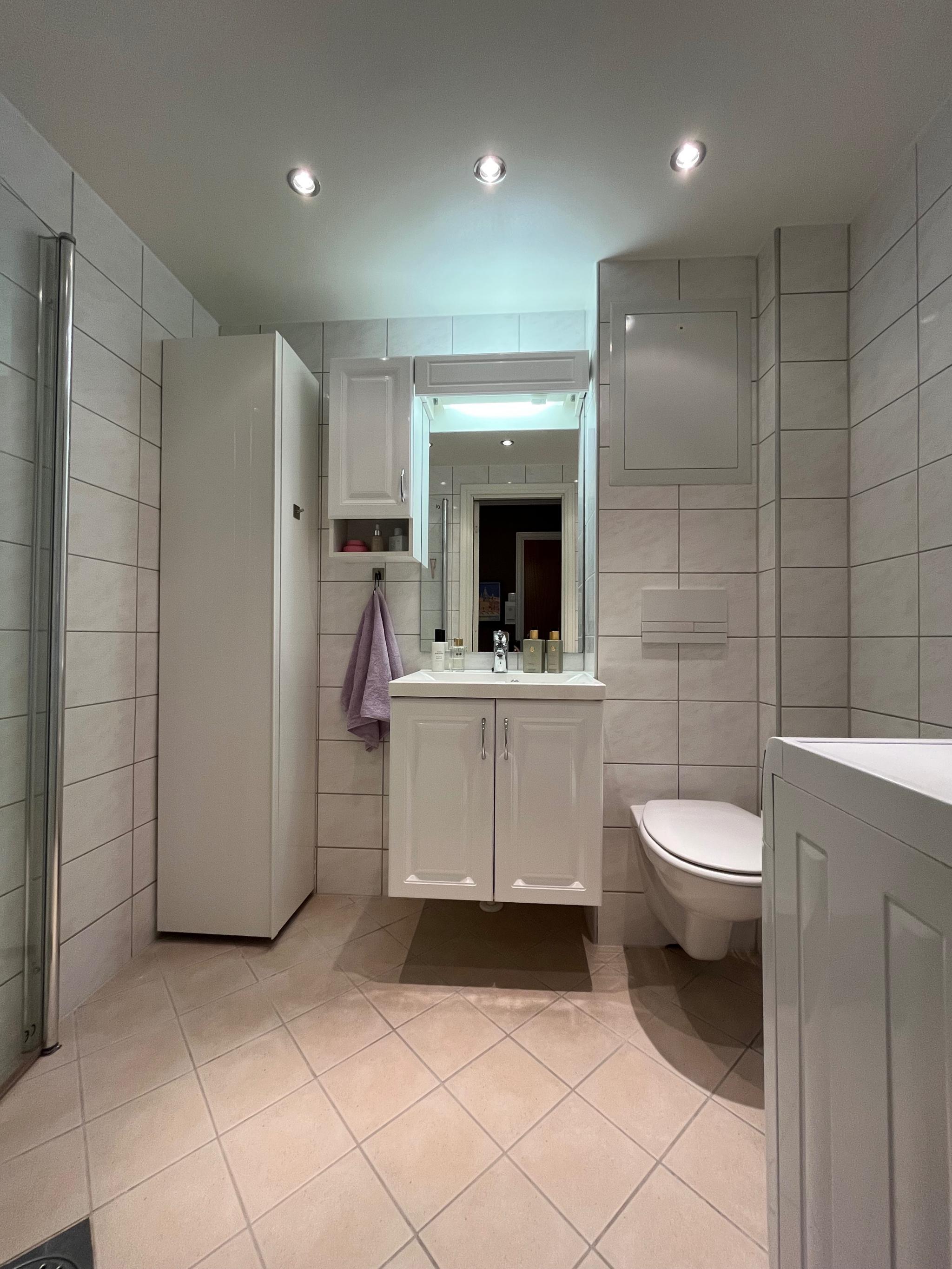 Bad med vaskemaskin og skapplass. 