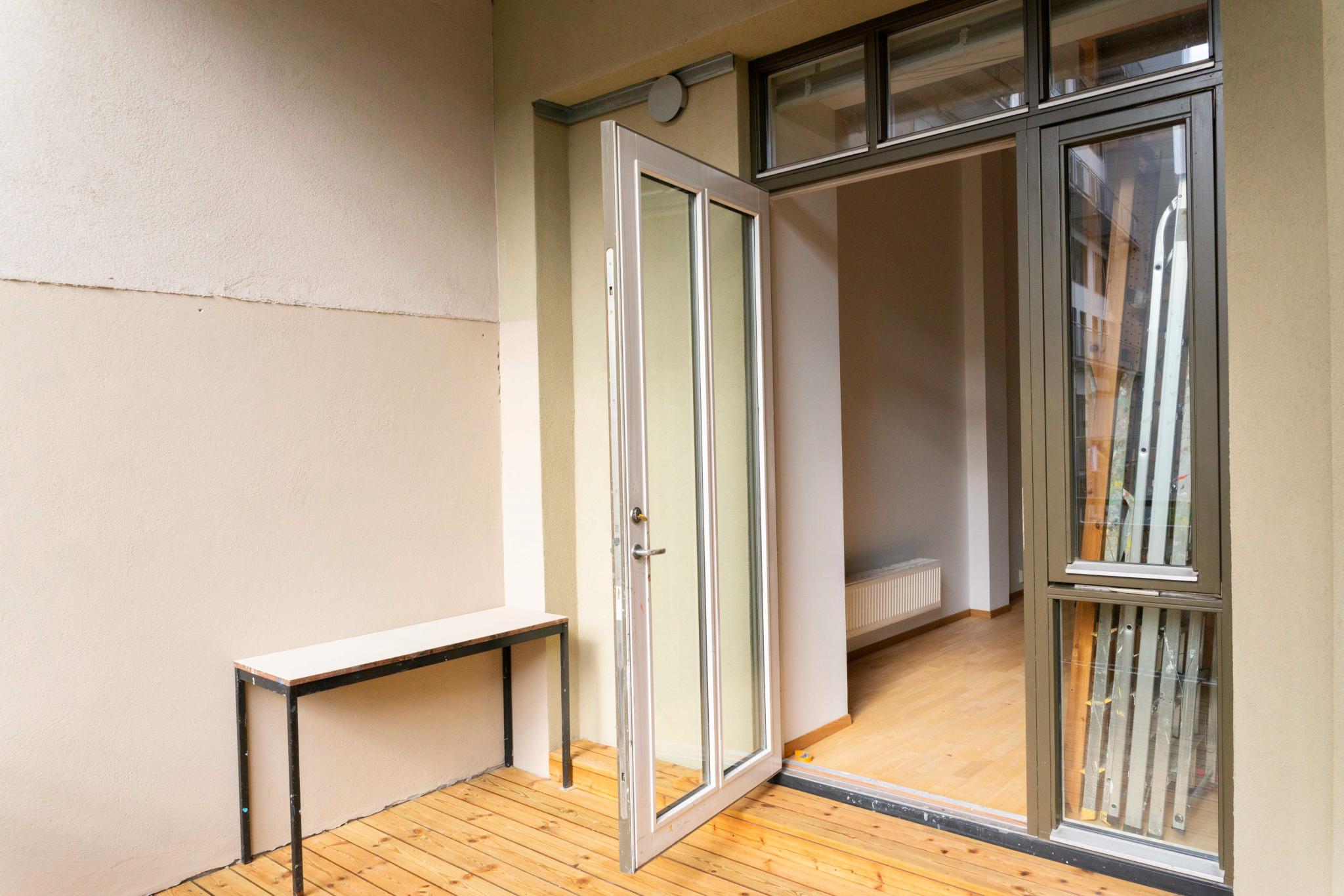 Romslig balkong med nyslipt tregulv byr på morgen- og formiddagsol