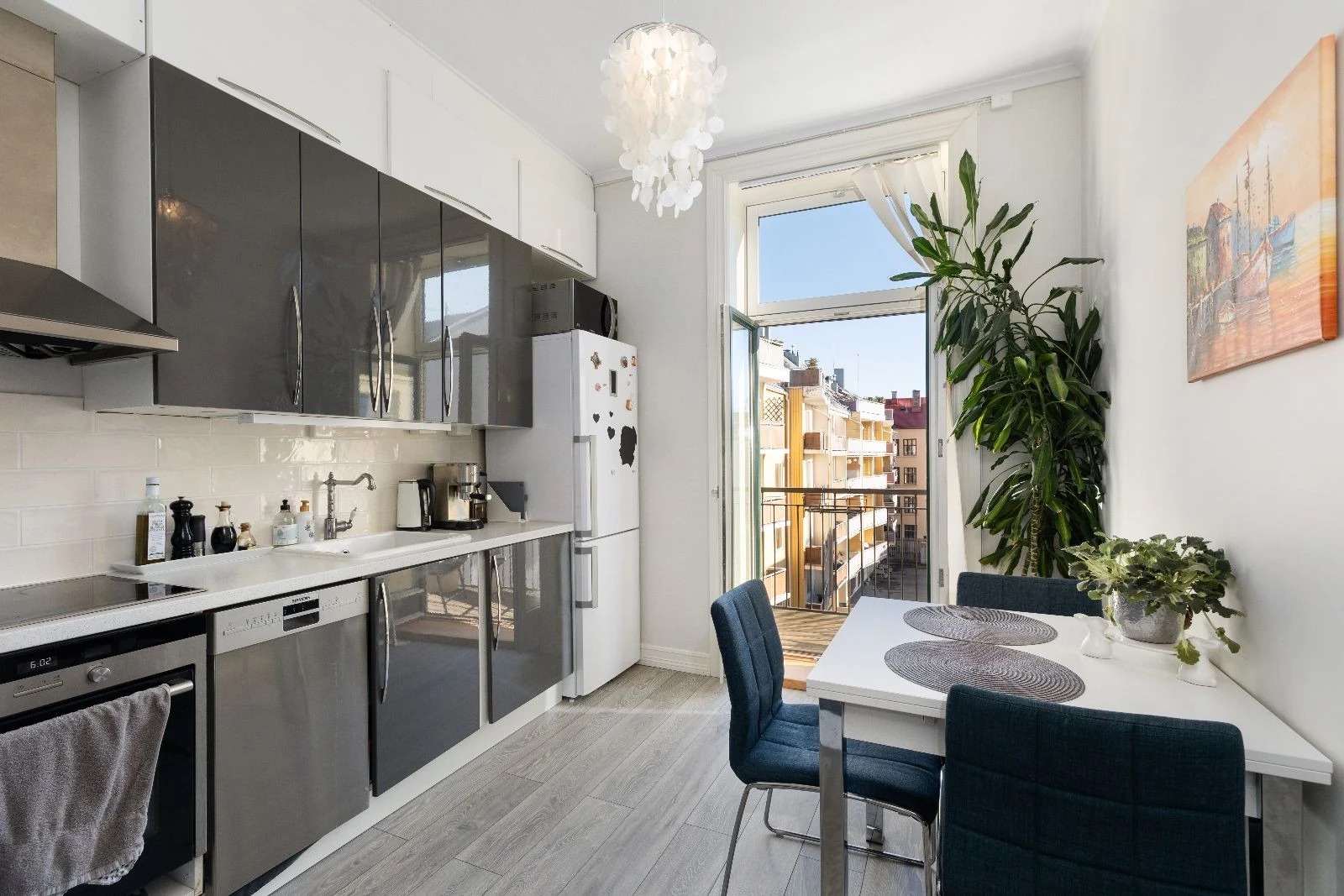 Separat kjøkken med utgang til balkong mot bakgård. (Benkeplass også i bakkant av bildet)
Frittstående hvitevarer: kombiskap, mikrobølgeovn. Integrerte hvitevarer: oppvaskmaskin, komfyr, steketopp.