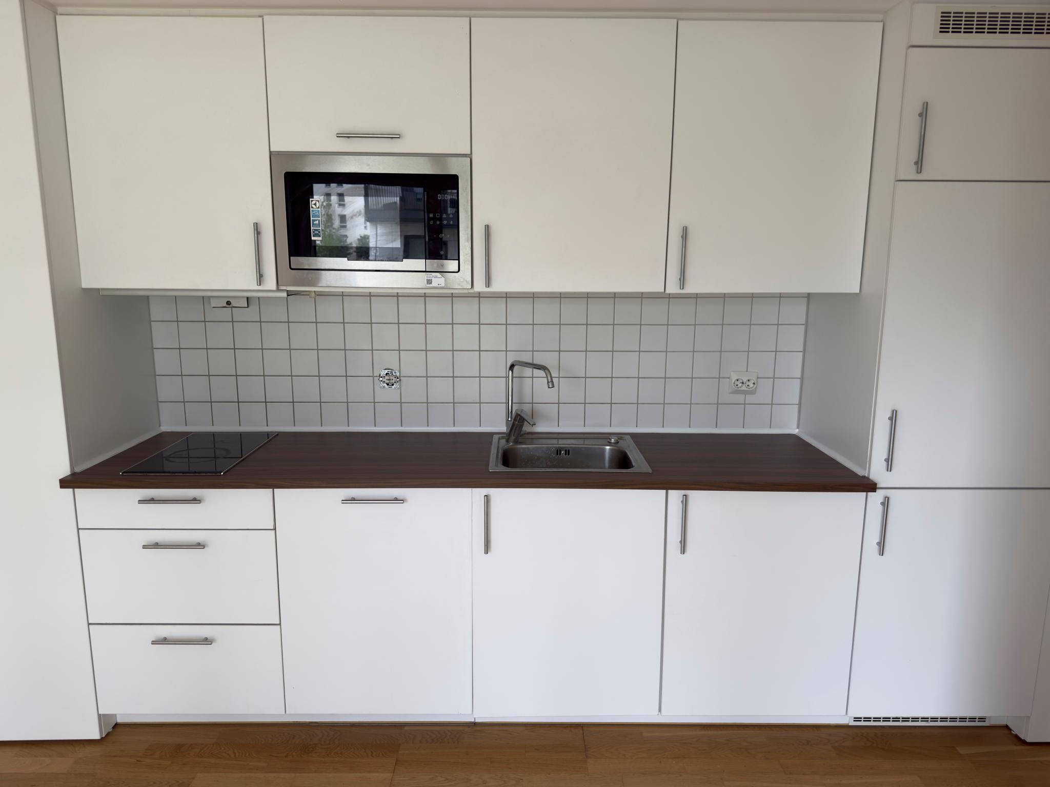 Moderne kjøkken med hvitevarer og ny benkeplate