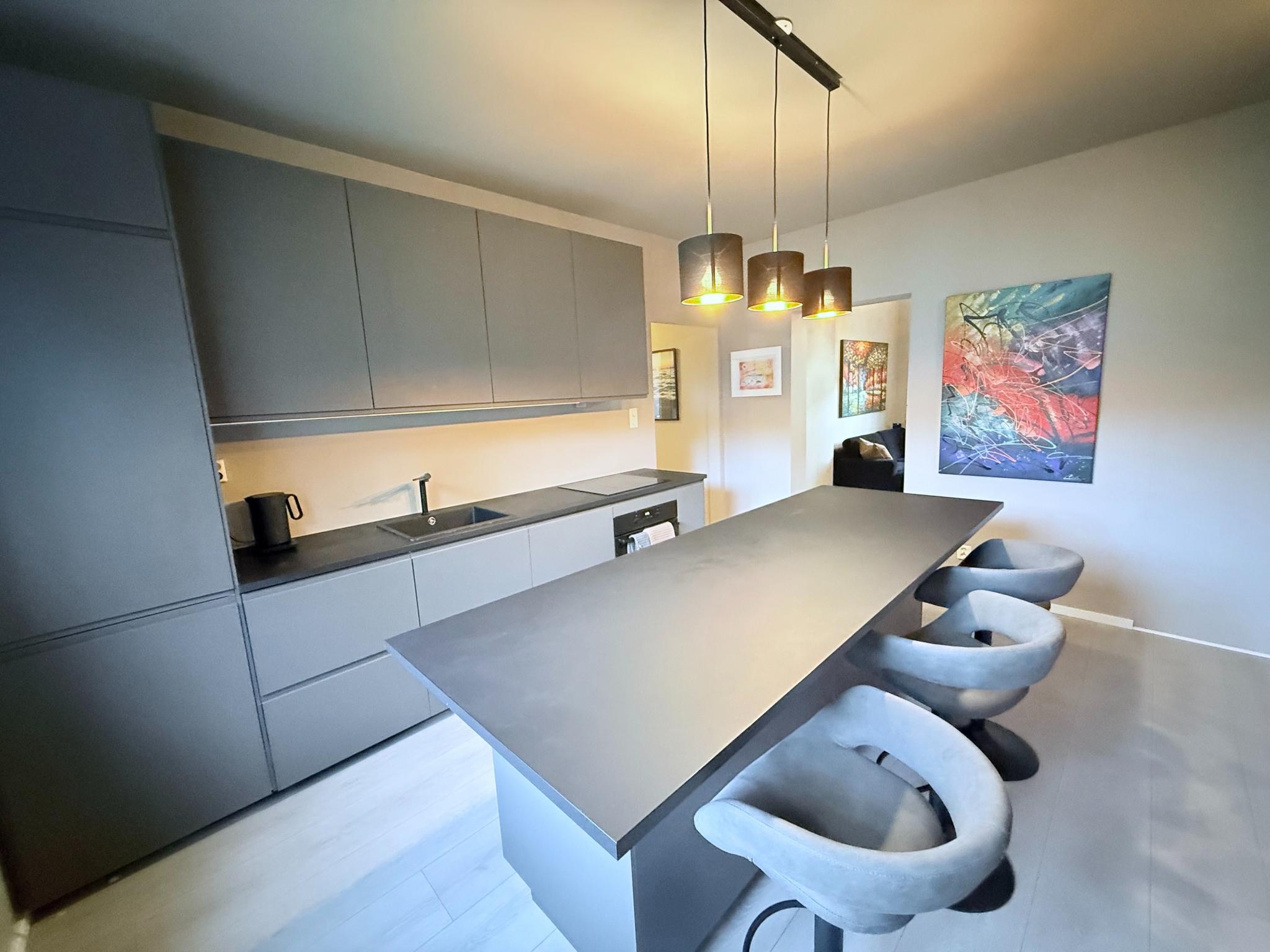 Kjøkken med god skapplass, integrerte hvitevarer og en stor kjøkkenøy for inntil 8 persone