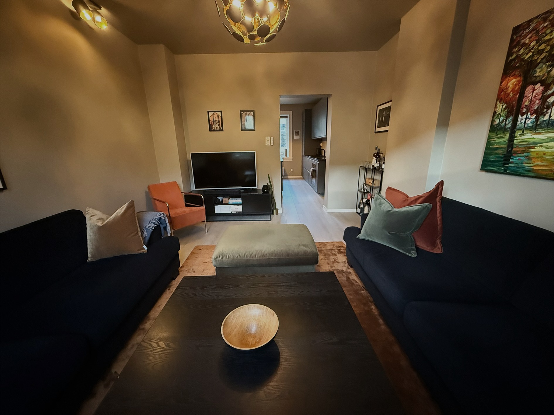 Romslig stue med to sofaer, tv og tv-benk