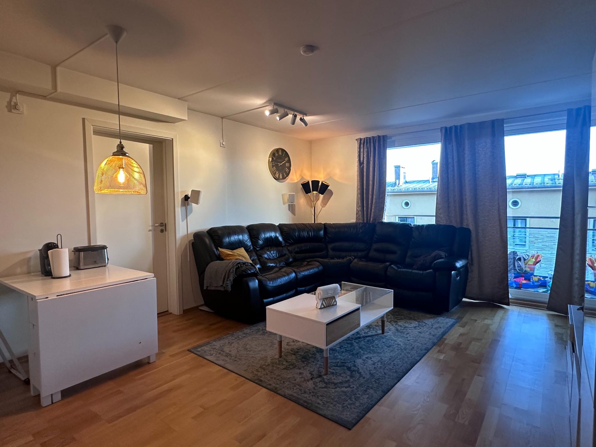 Lys og romslig stue med store vindusflater – utgang til solrik balkong.

