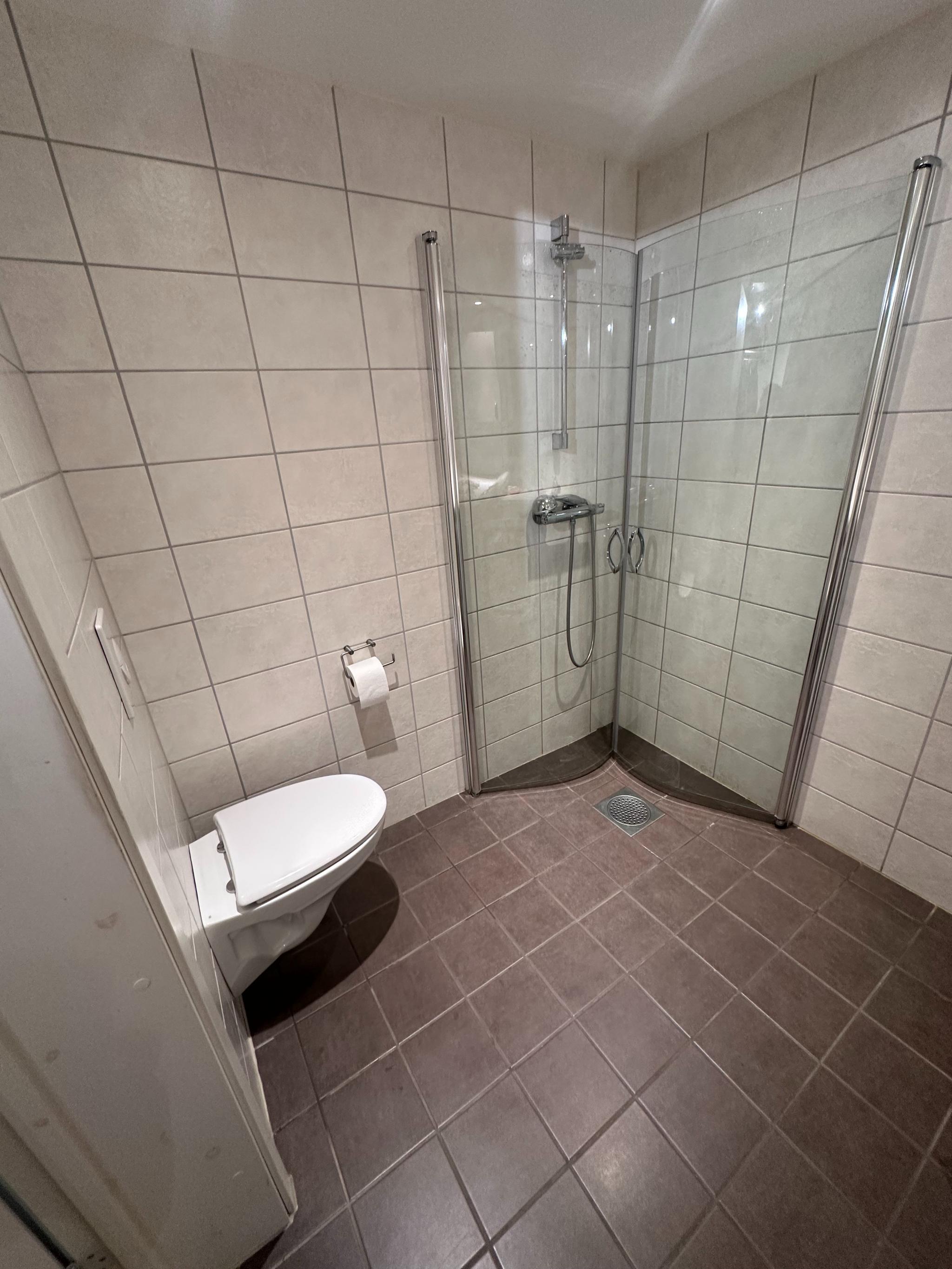 Bad/wc med fliser, vaskemaskin og oppbevaringsplass