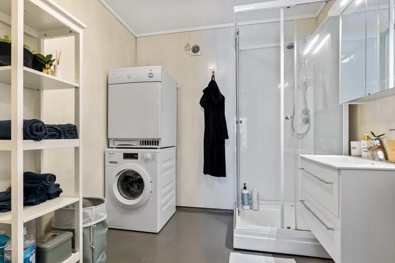 Bad med dusj, og vaskemaskin og tørketrommel.