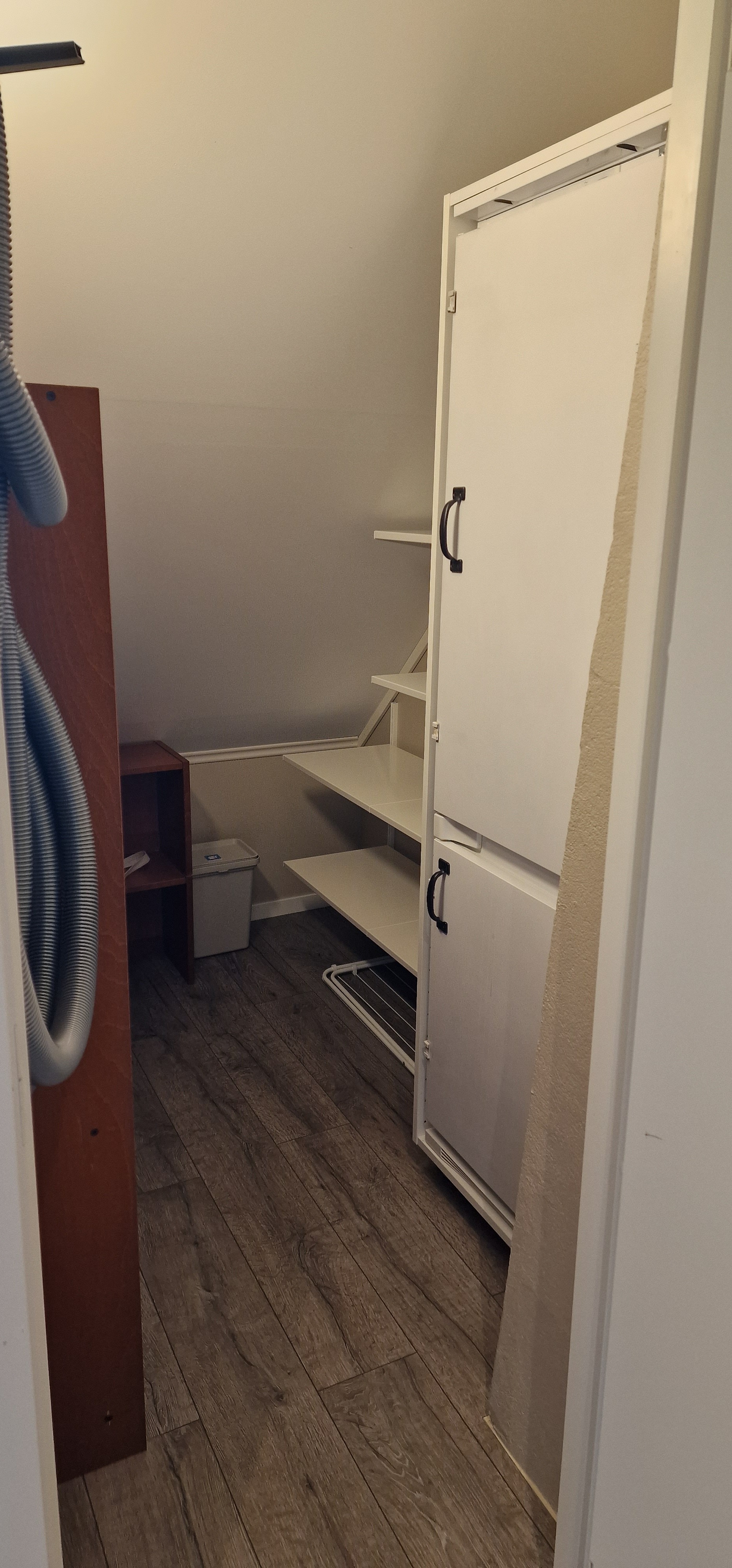 Bod med kjøl/frys, strykejern, strykebrett, vaskeutstyr og hyller for oppbevaring, tørkestativ x 2. Sentralstøvsugeren henger her. 