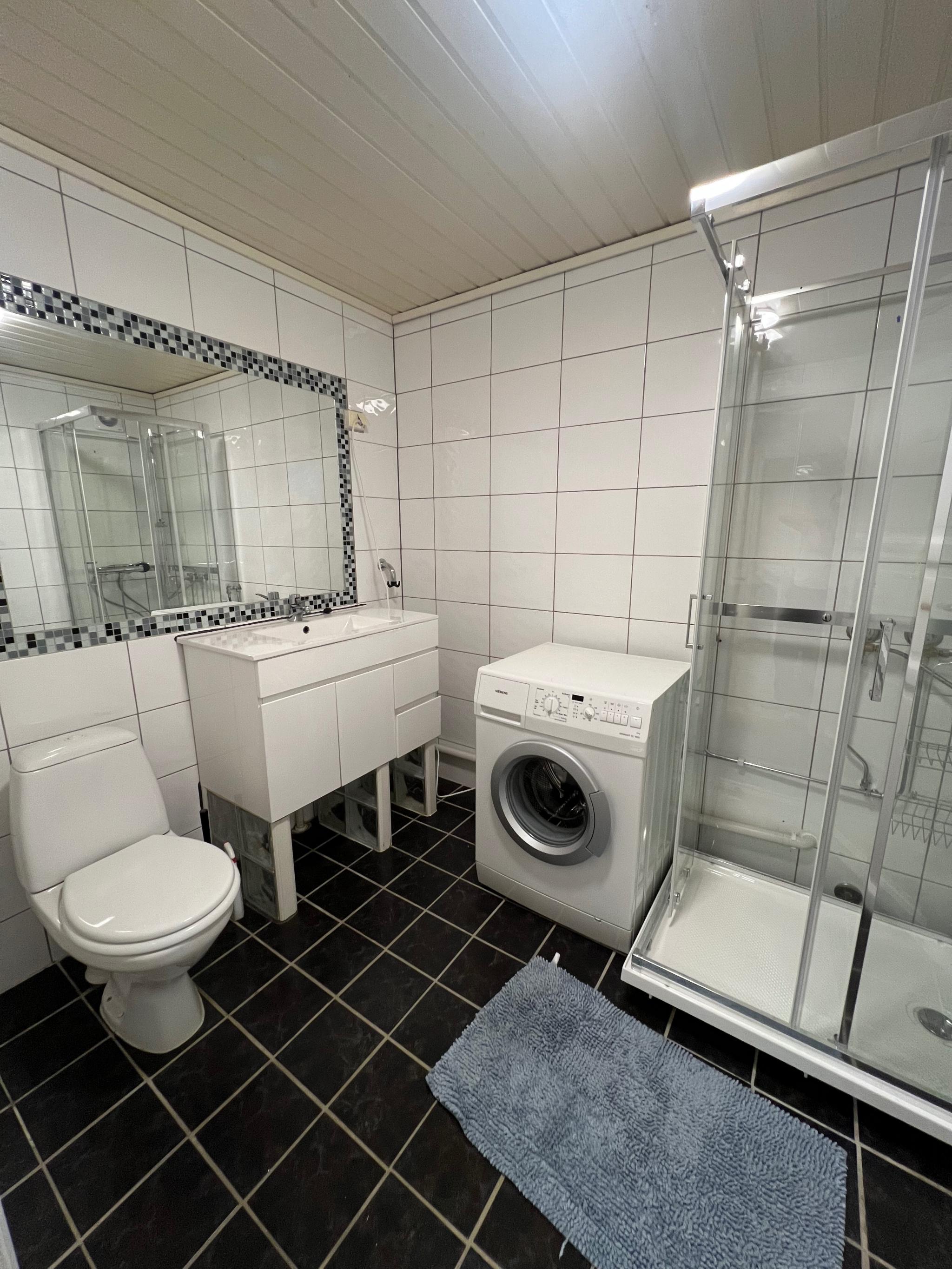 Baderommet med vaskemaskin og nytt dusjkabinett.