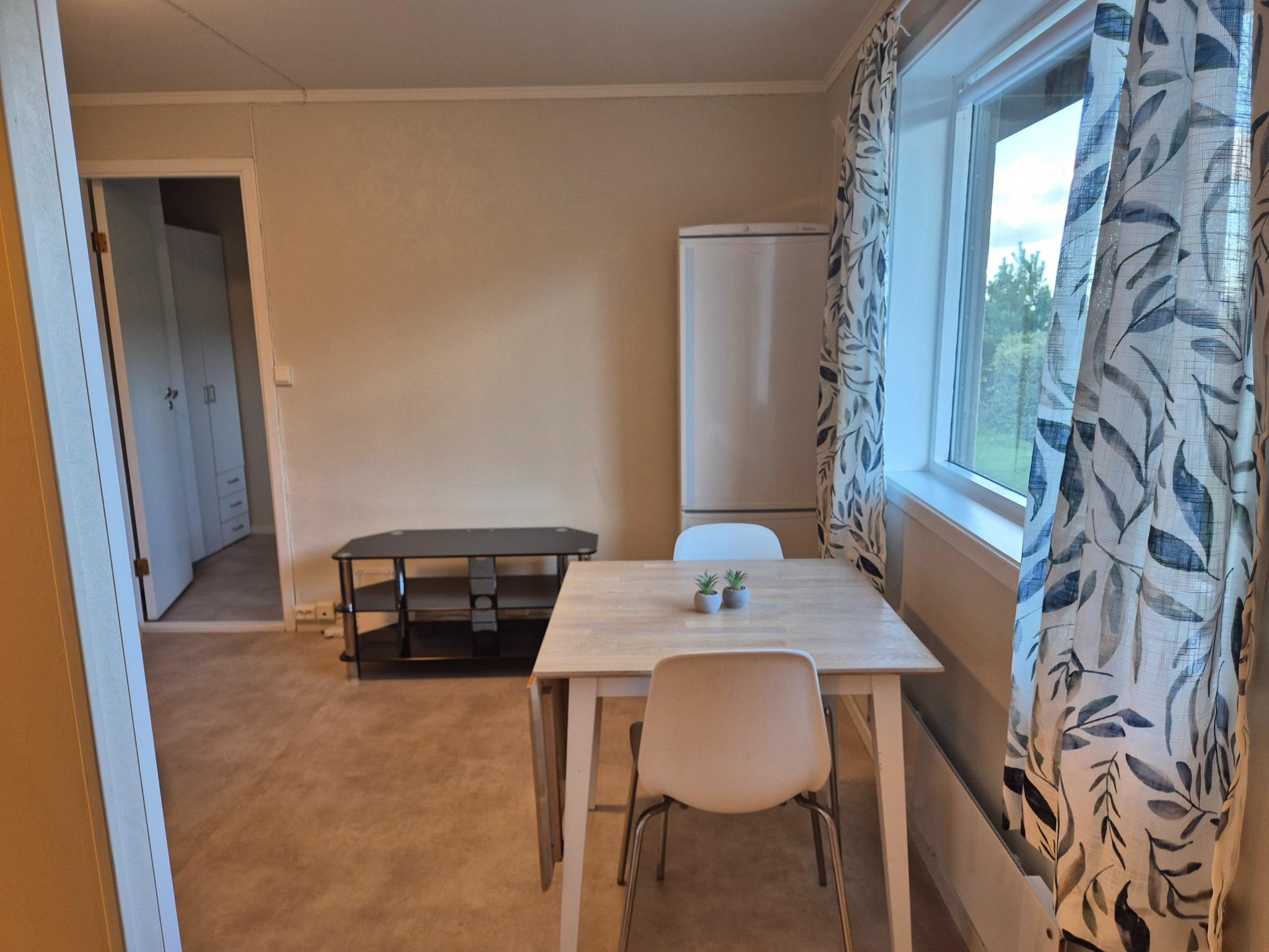 Spisebord og kjøleskap/fryser.