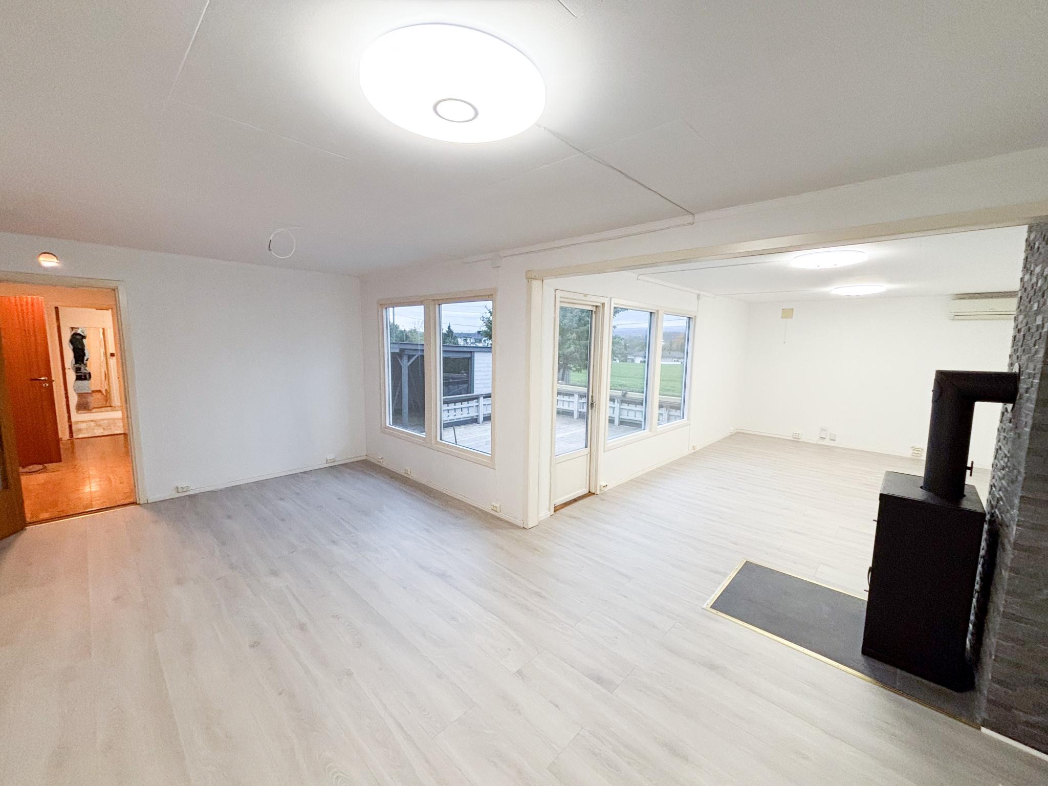 Lys og romslig stue med ny laminat, nymalte vegger og smarte lamper som kan styres med mobilen