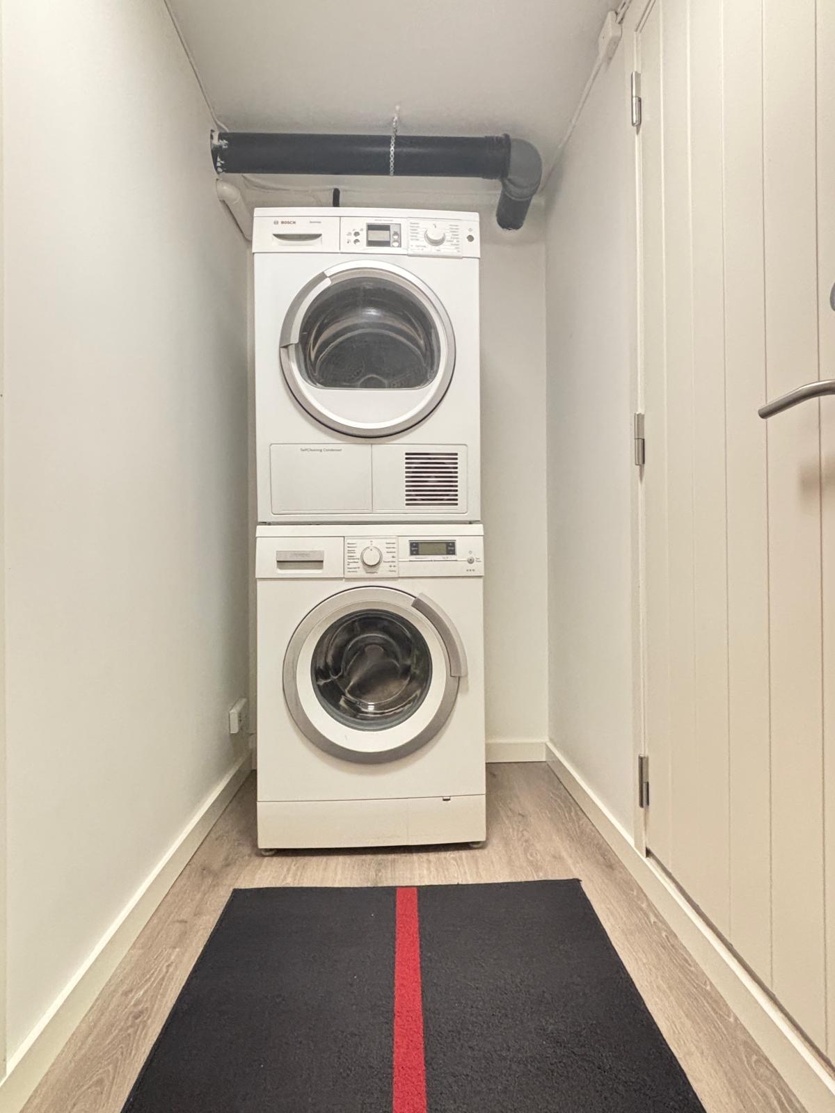 Vaskemaskin og tørketrommel i gangen- det er så en til dør med lås inn til hybelen.
