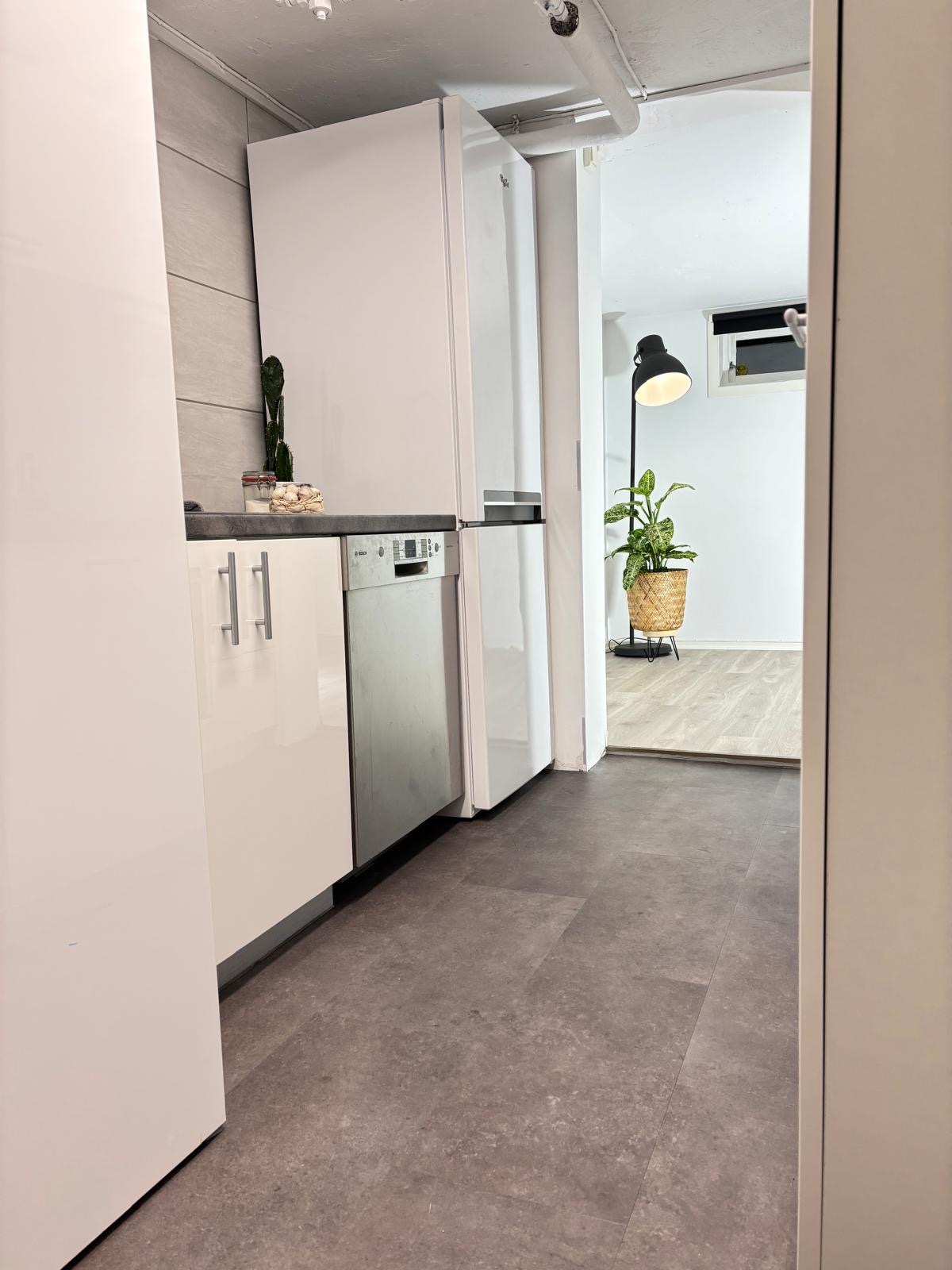 Kjøkken med moderne hvitevarer og god plass for oppbevaring