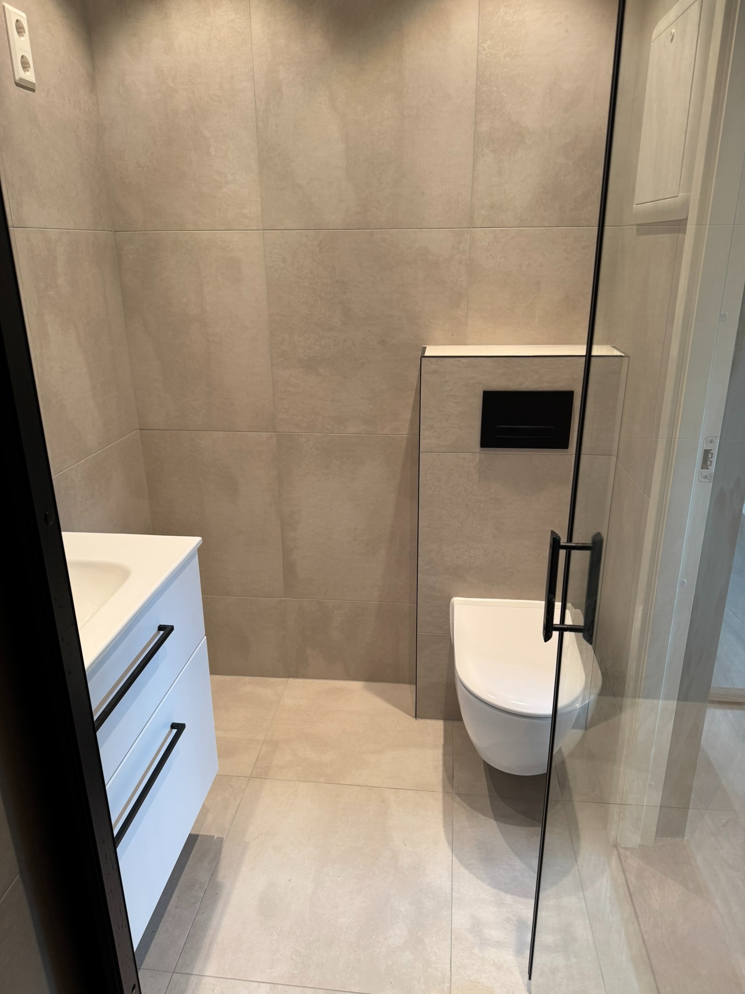 Bad med vegghengt toalett og plass til vaskemaskin.