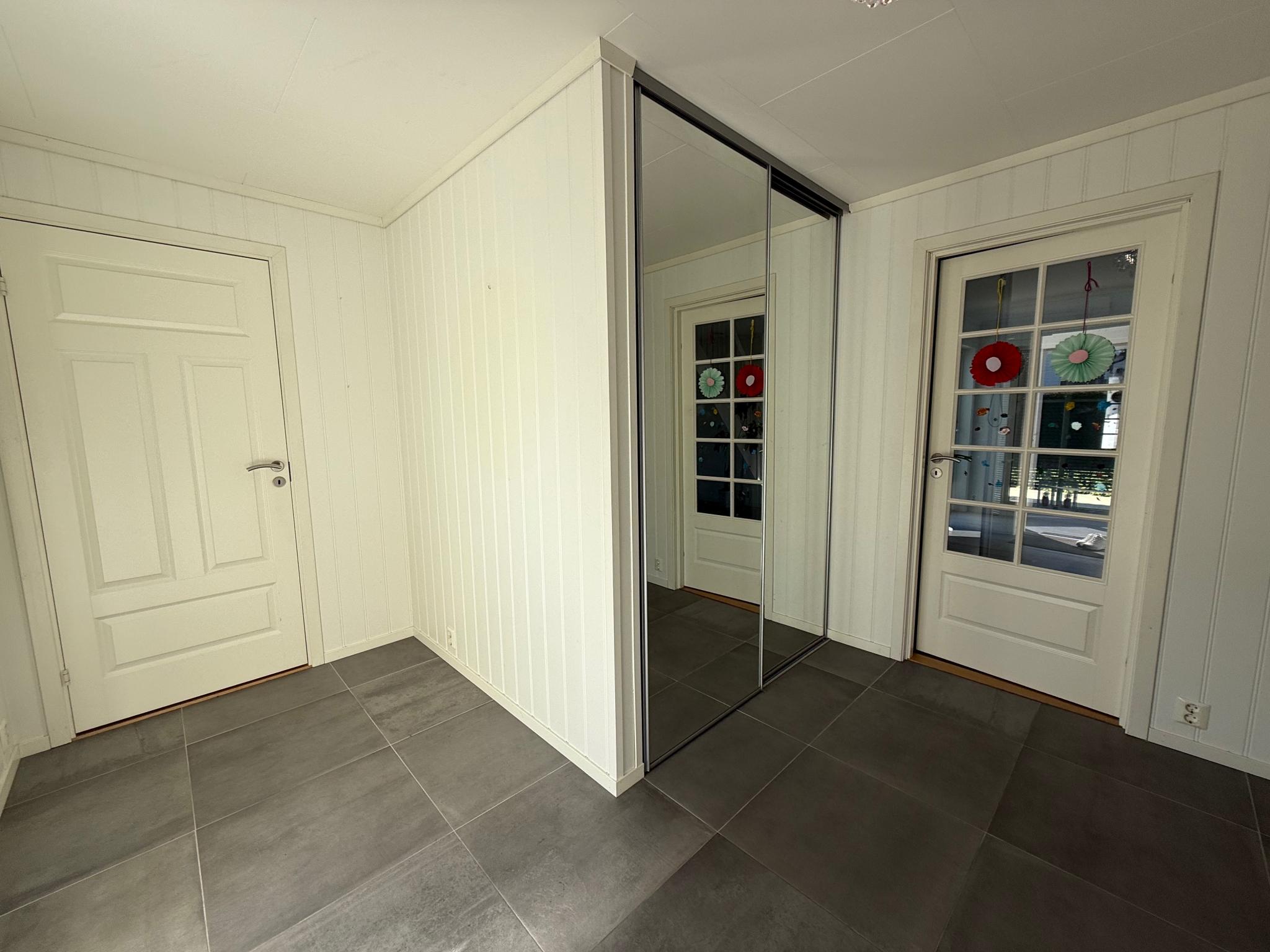 Skyvedørsgarderobe med speil. 
Inngang til bad/vaskerom i 1. etasje. 