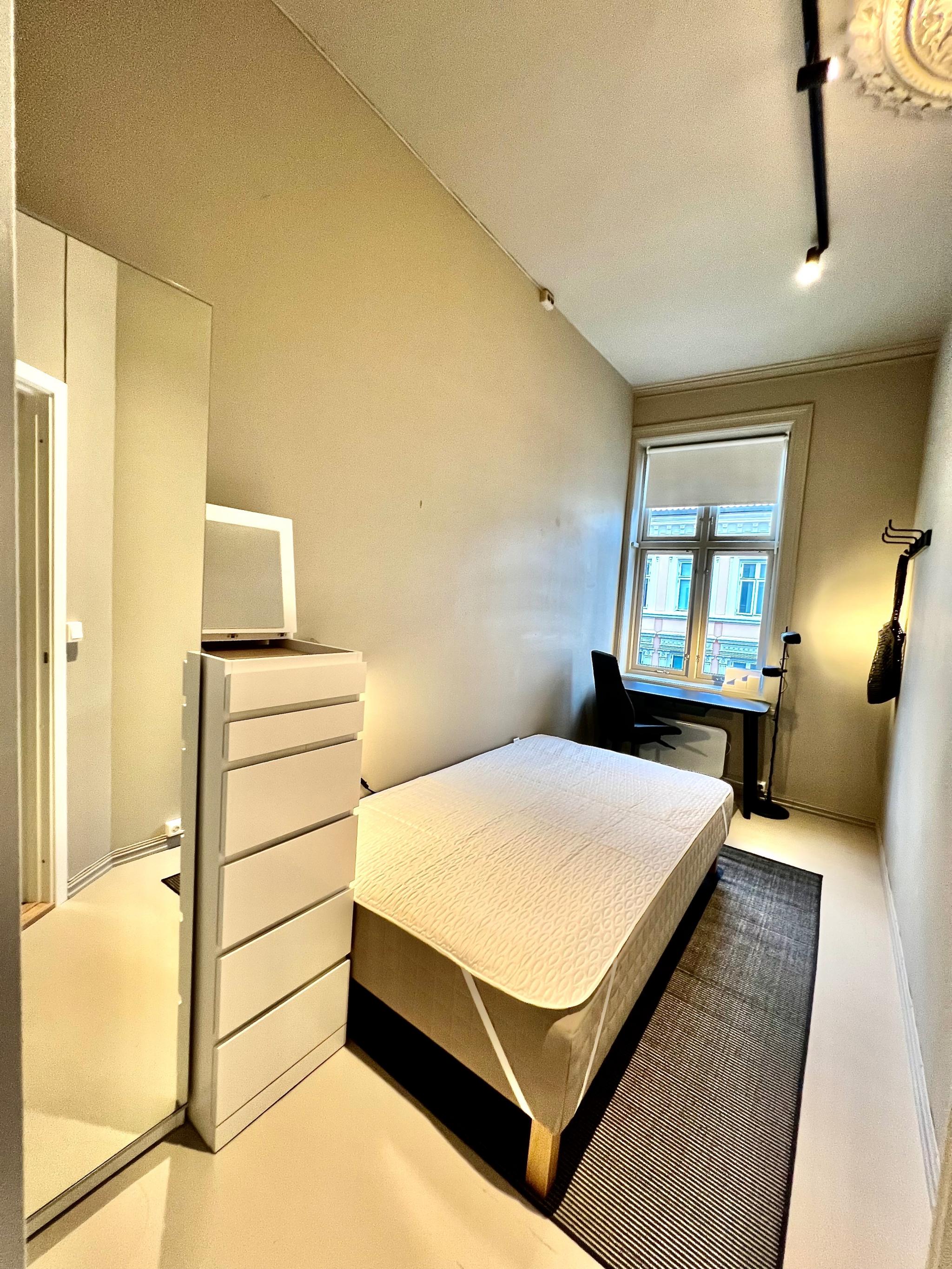 Soverom 9m2 inneholder 120 seng, garderobeskap med heng og hyller, arbeidsbord med stol, speil, tepper og lamper.