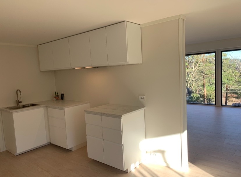 Fra kjøkken ut i stue med store gode vinduer.