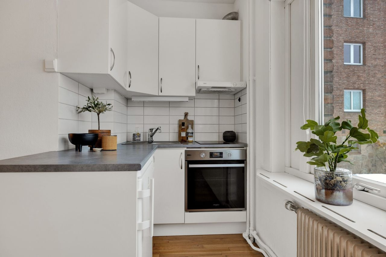 Kjøkken med hvitevarer, oppvaskmaskin, stekeovn, platetopp, kjøleskap, vannkoker, annet utstyr. 