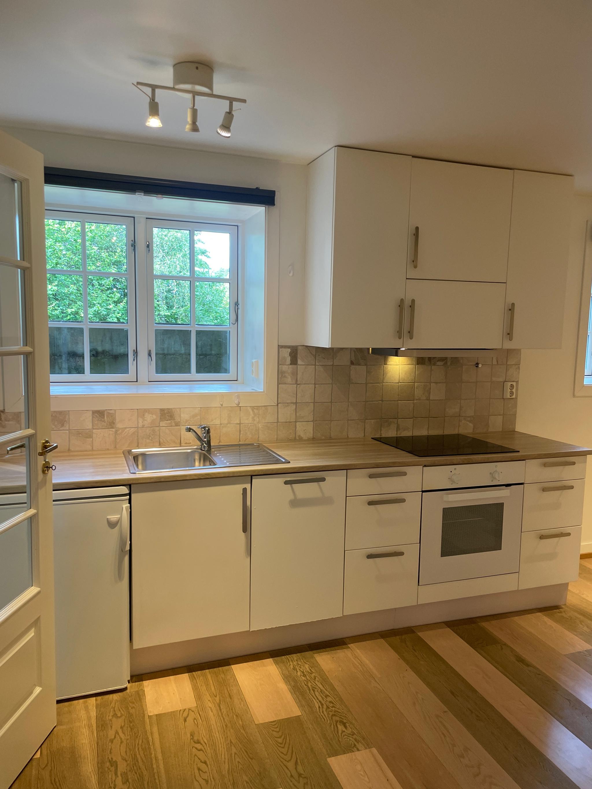 Kjøkken med kjøleskap og oppvaskmaskin