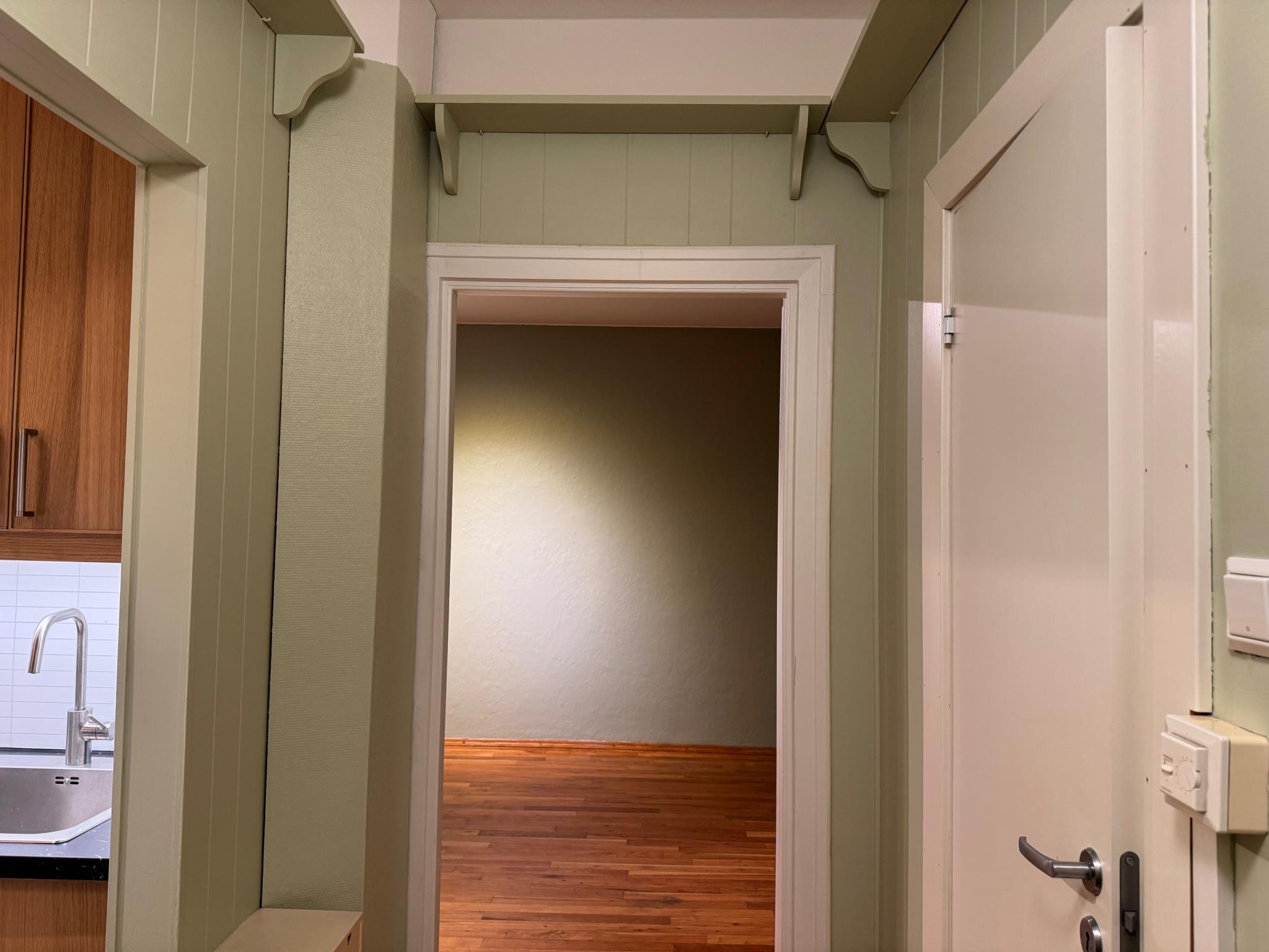 Gang med inngang til bad, soverom, stue og kjøkken.