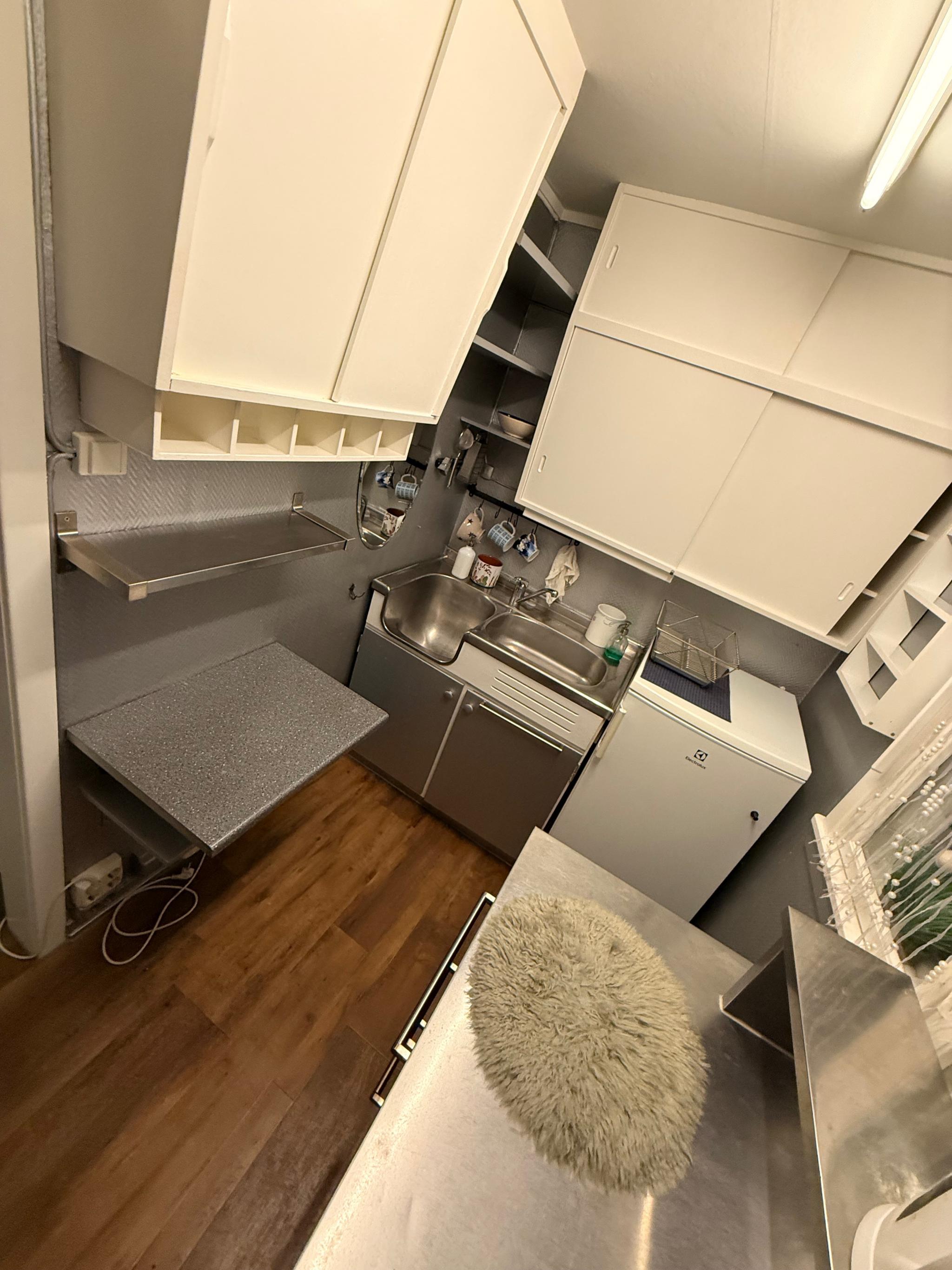 Hyller, uttrekkbar bordløsning og godt lys fra vindu. Perfekt for én eller to personer.