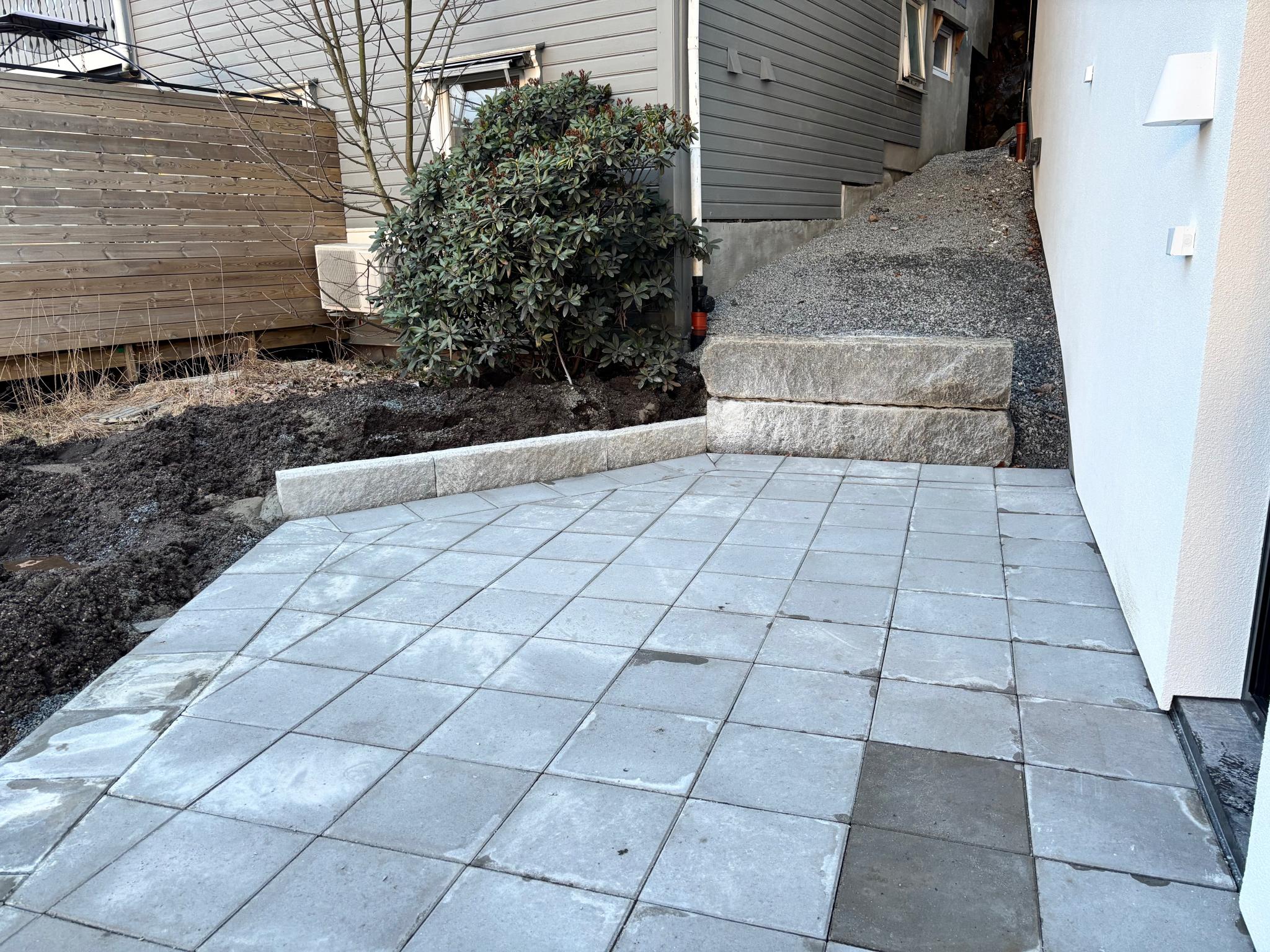 Uteplass tilhørende leiligheten ferdigstilles i vår. Hekk kommer rundt plattingen. 