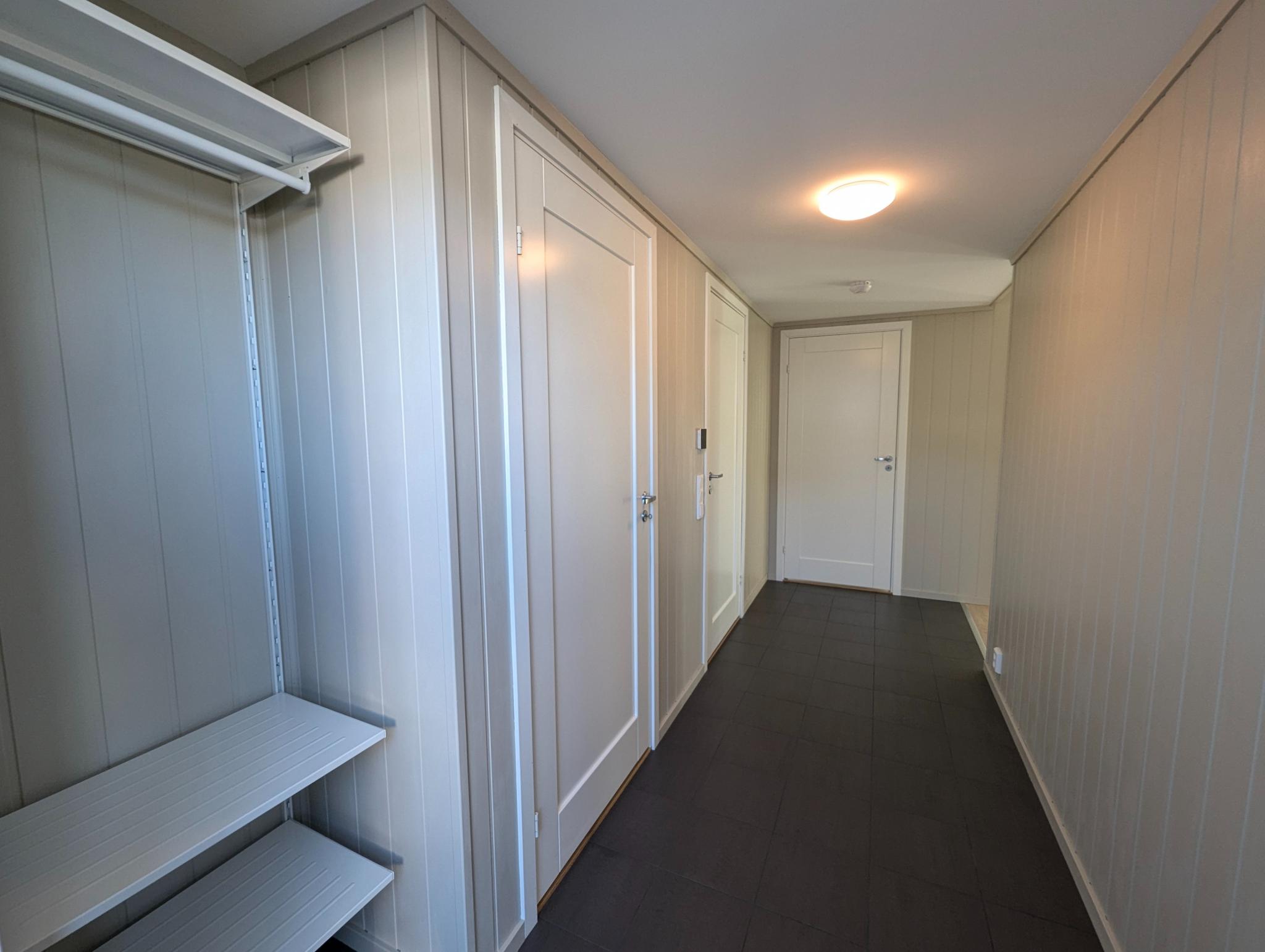 Flislagt entre med gulvvarme og god plass for oppbevaring av yttertøy og sko