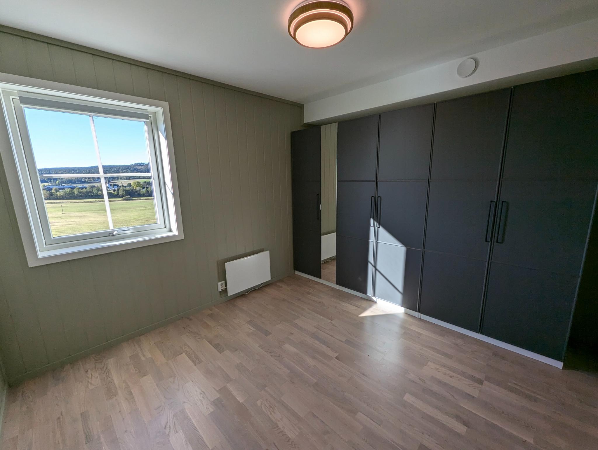 Utsikt mot Bjørkelangen fra soveromsvinduet og romslig garderobeløsning