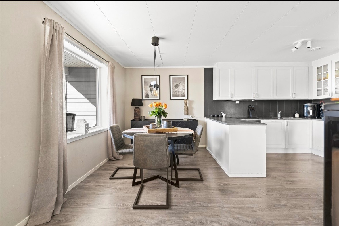 Pent kjøkken med god skap og benkeplass, innredningen består av profilerte fronter laminert benkeplate. Flis over benkeplater belysning og kjøkkenkum.