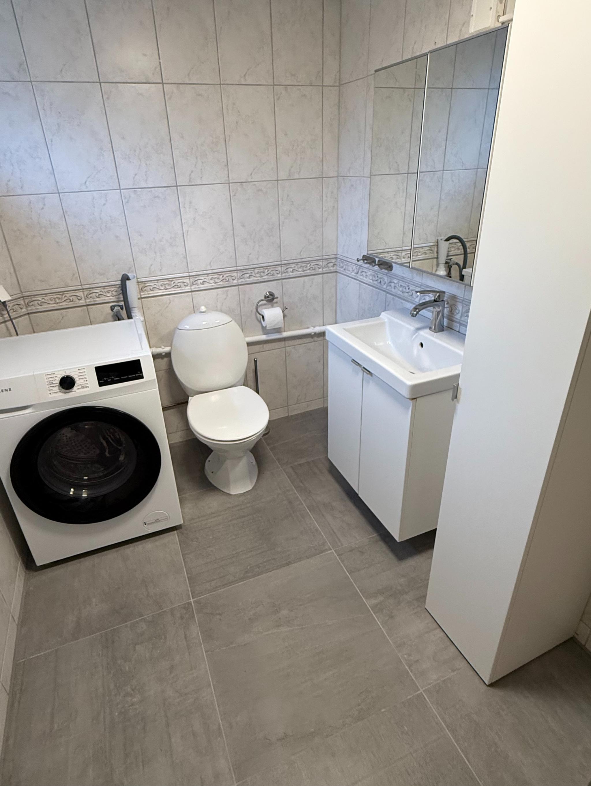 Fliselagt baderom med varmekabler. Det er god lagringsplass i underskap, speilskap og høyskap.