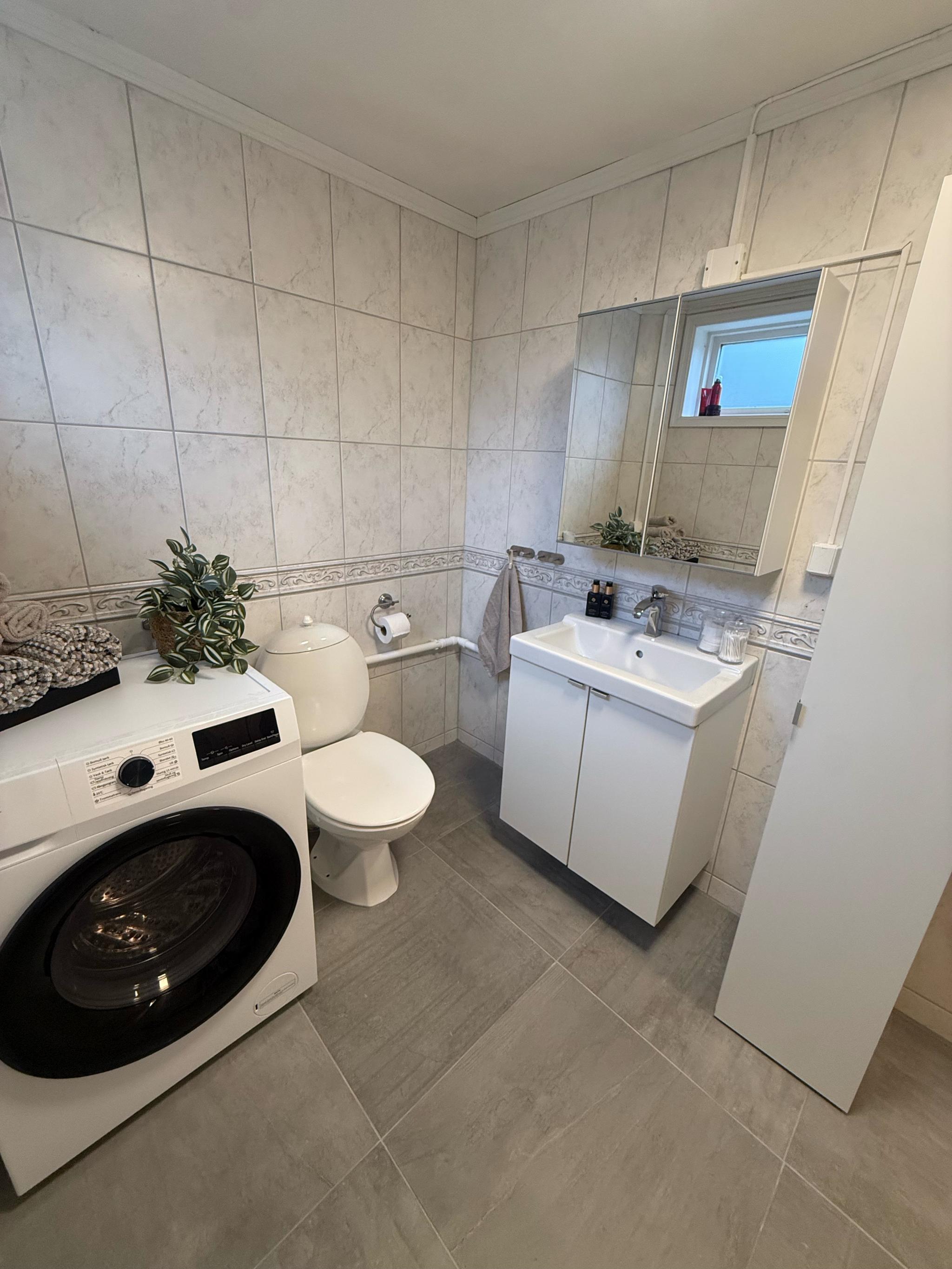 Baderom med god lagringsplass og egen vask- og tørkemaskin