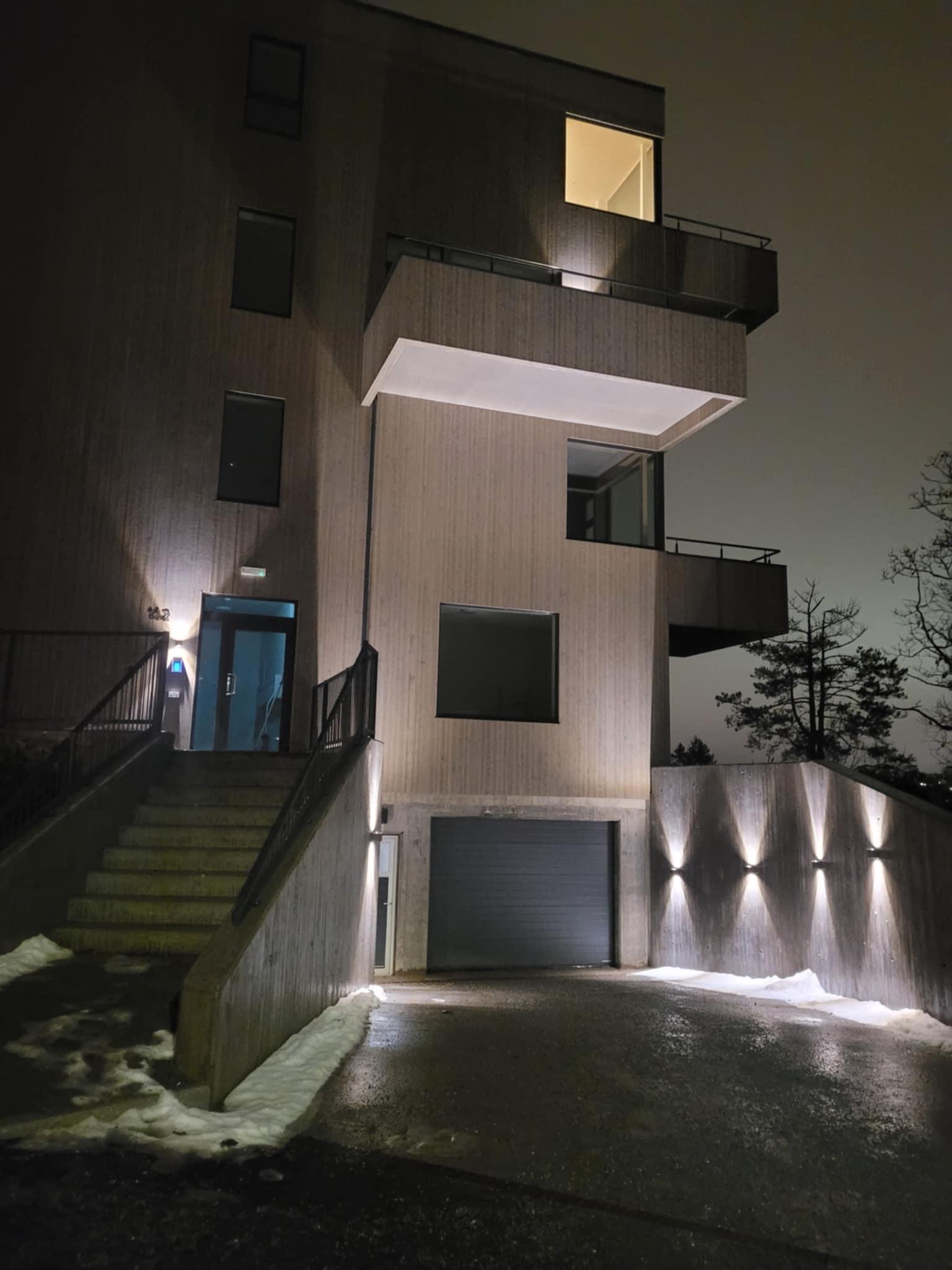 Inngang til leilighet opp trappen til venstre og parkeringsanlegg nede til høyre