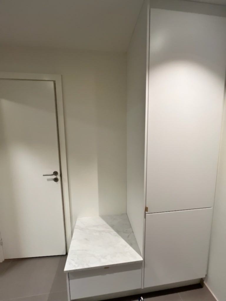 Gang med garderobe, benk og skoskuff og flislagt gulv