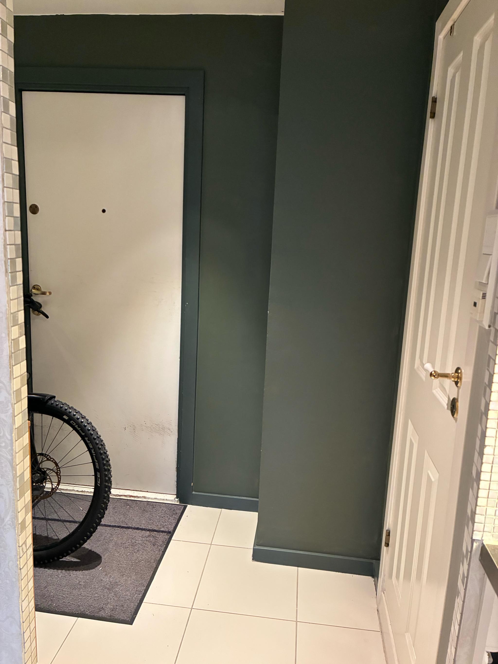 Deler av gangen med plass til lagring av sykkel, et stort garderobeskap og en kommode her eller på veranda