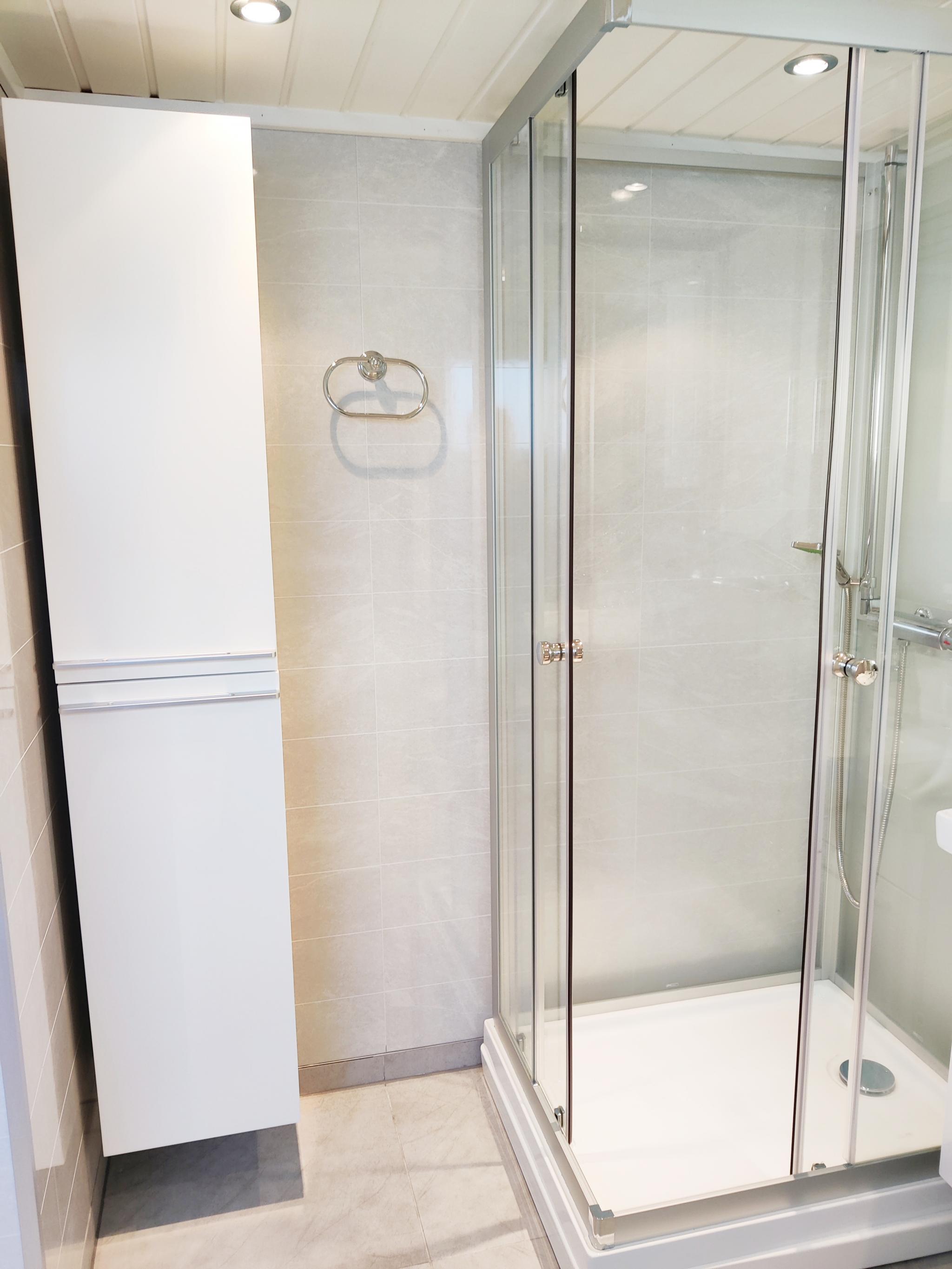 Dusjkabinett og rikelig skapplass på badet.