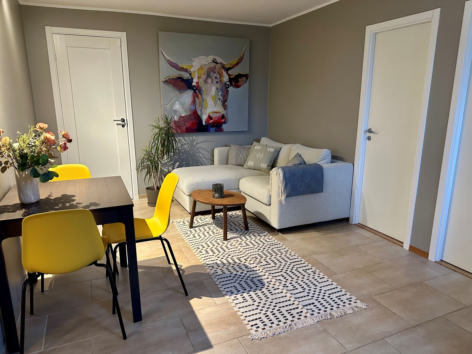 Spisegruppe og stue. Inngangen til de to soverommene er til høyre på bildet. Døren på bakveggen er inn til utleiers del av kjelleren.