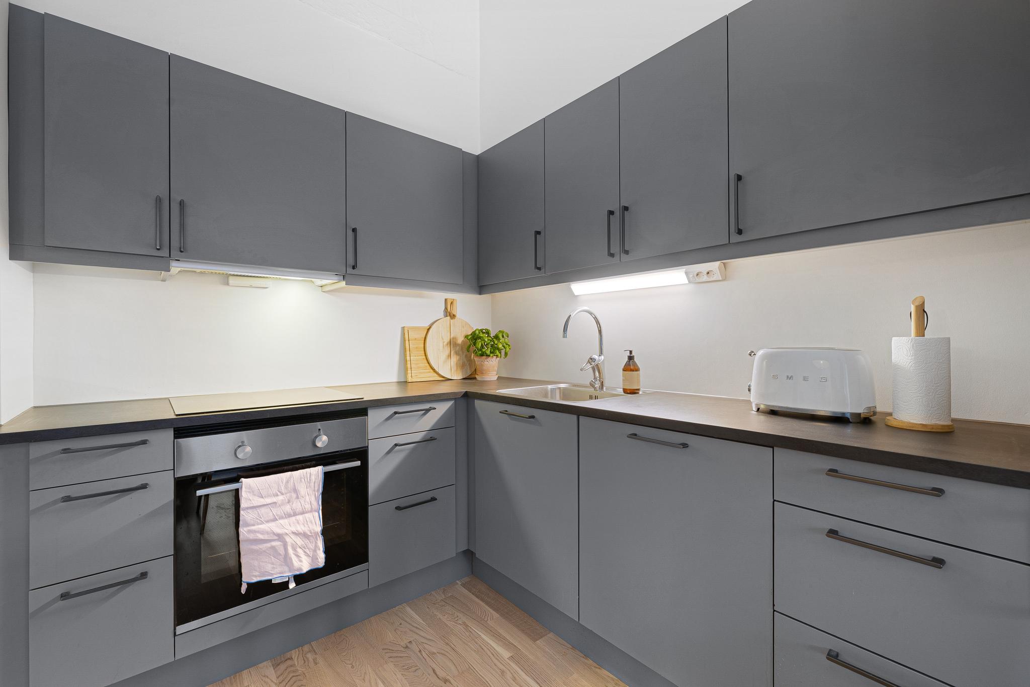 raktisk og veldisponert kjøkken med gjennomført design og tiltalende farger.