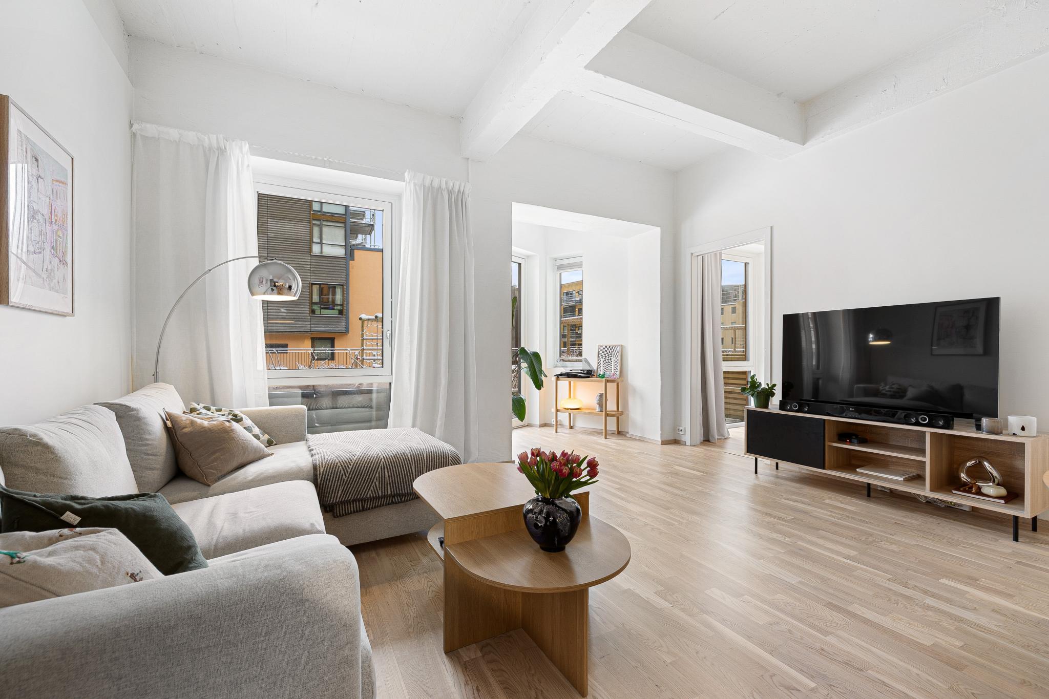 Lys stue med store vindusflater og åpen løsning – et rom som oppleves svært luftig og inviterende. 3 meter under taket.